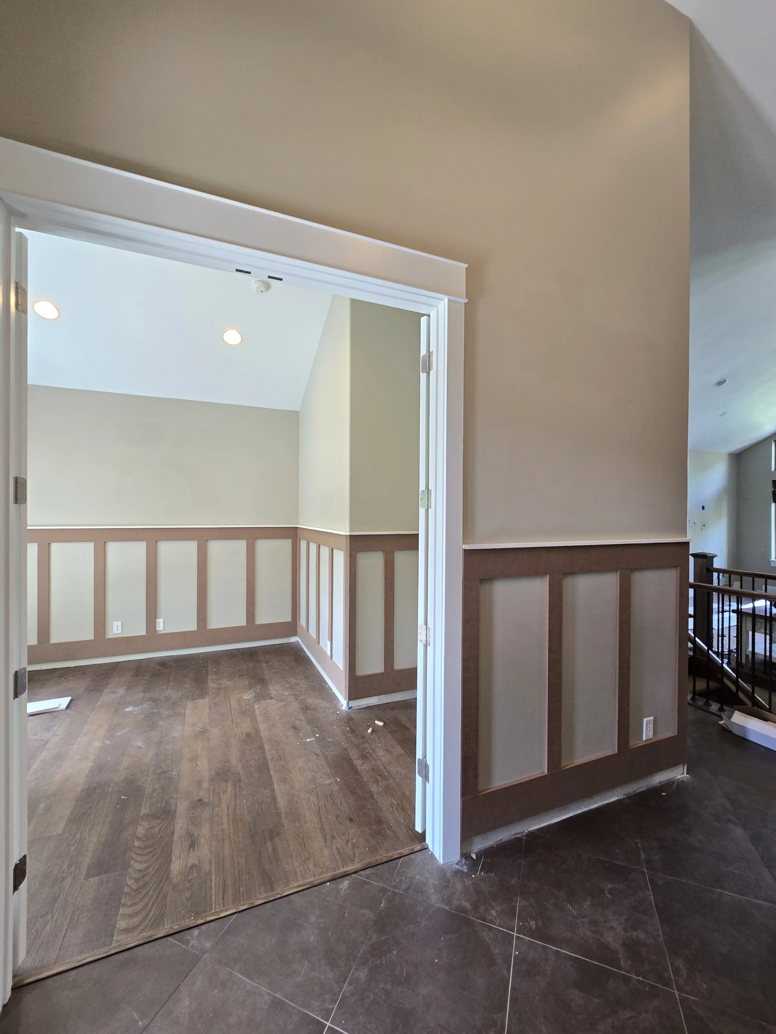 Custom board and batten wall paneling installed by CBR Interiors in a Utah home office and hallway. The trim layout wraps continuously through the adjoining spaces to create a clean, cohesive design.