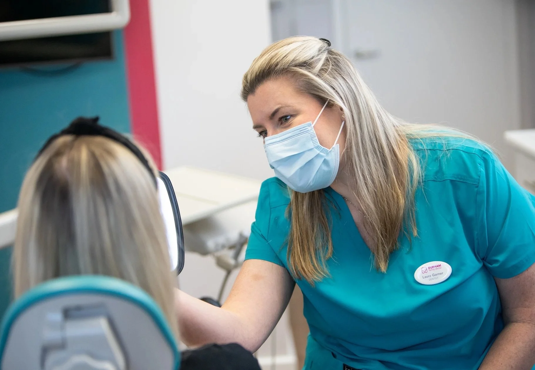 Dentist examining patient smile at Durham Family Dental