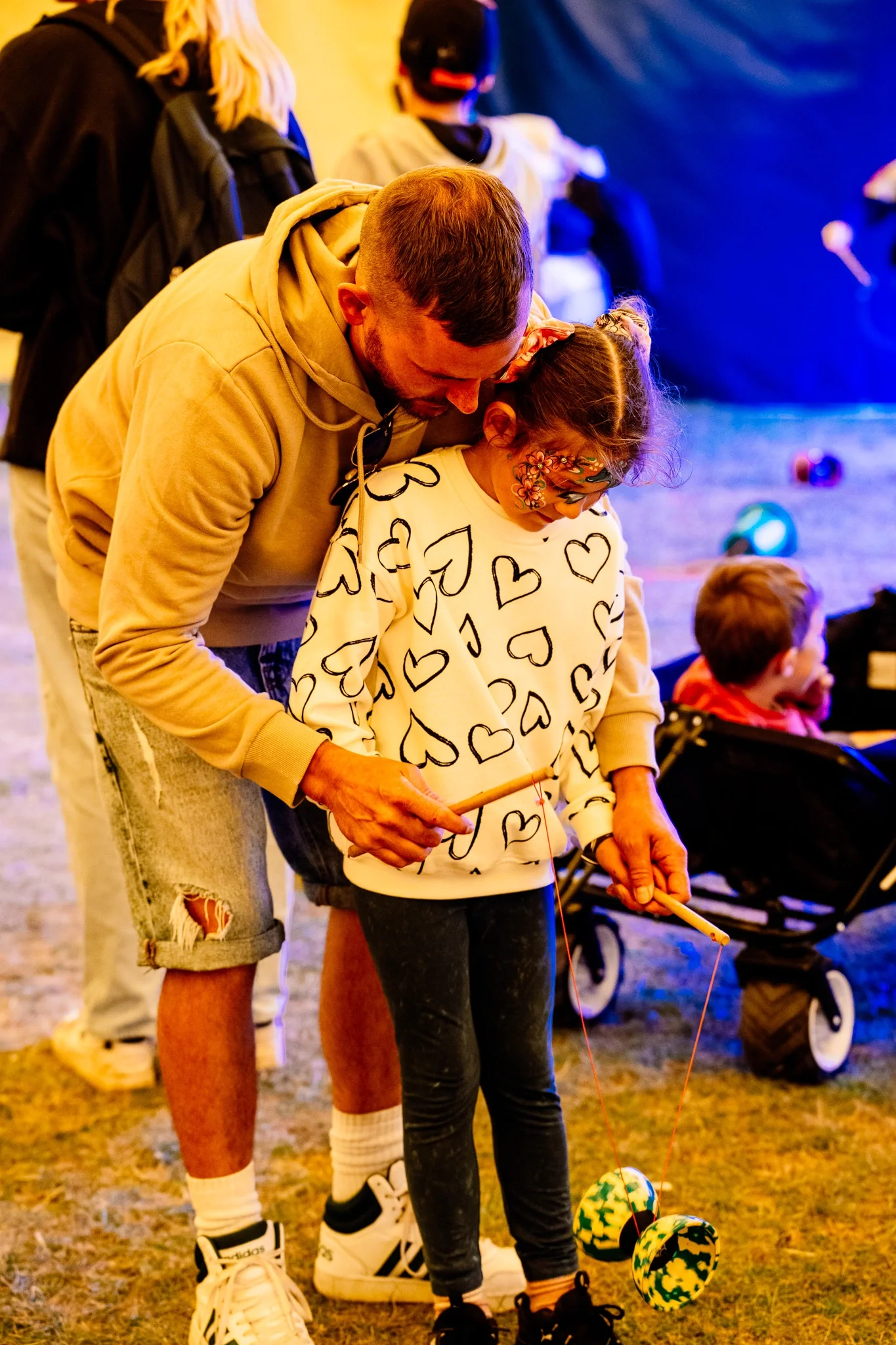 young father helping his daughter practice diabolo