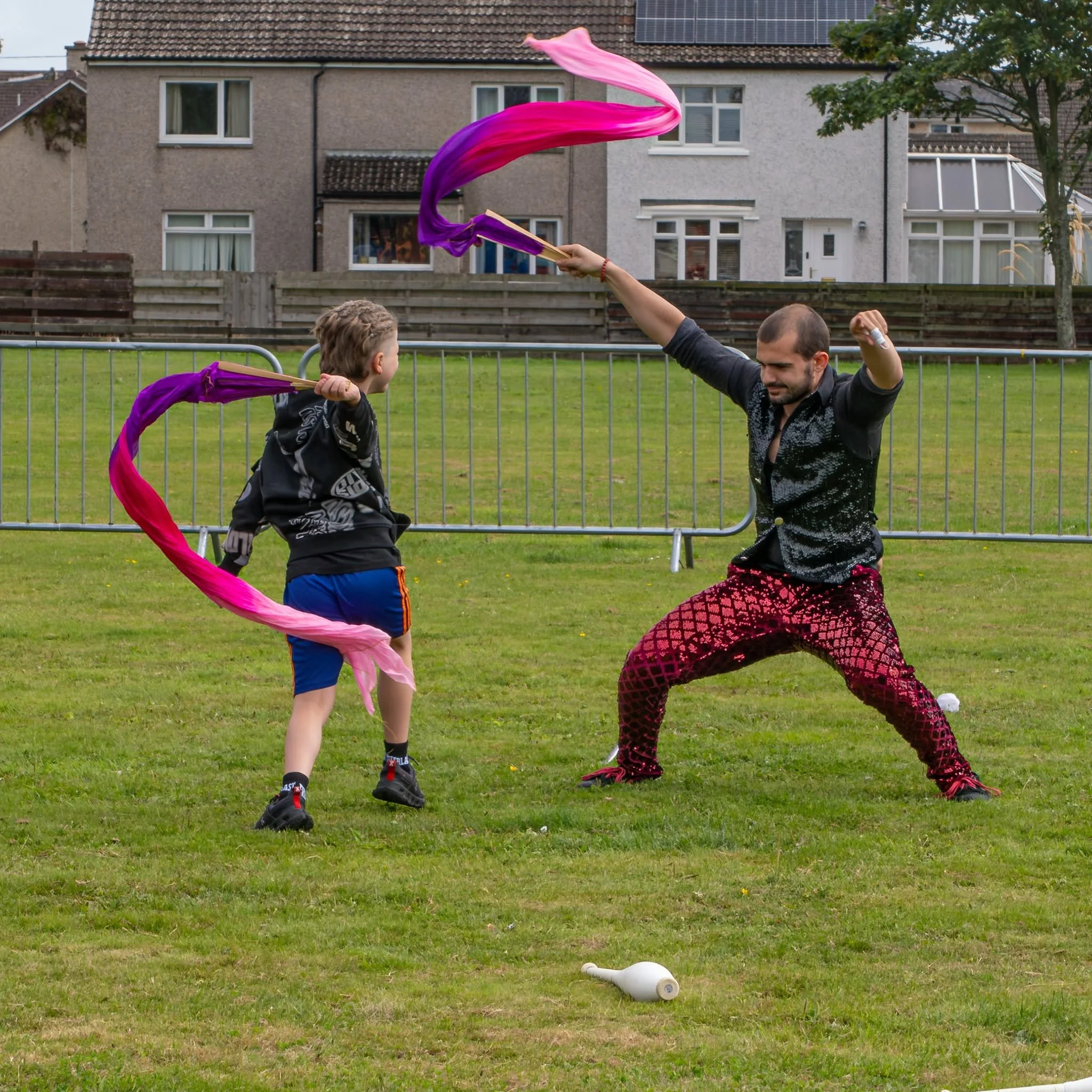 action shot of performer with child playing with ribbons