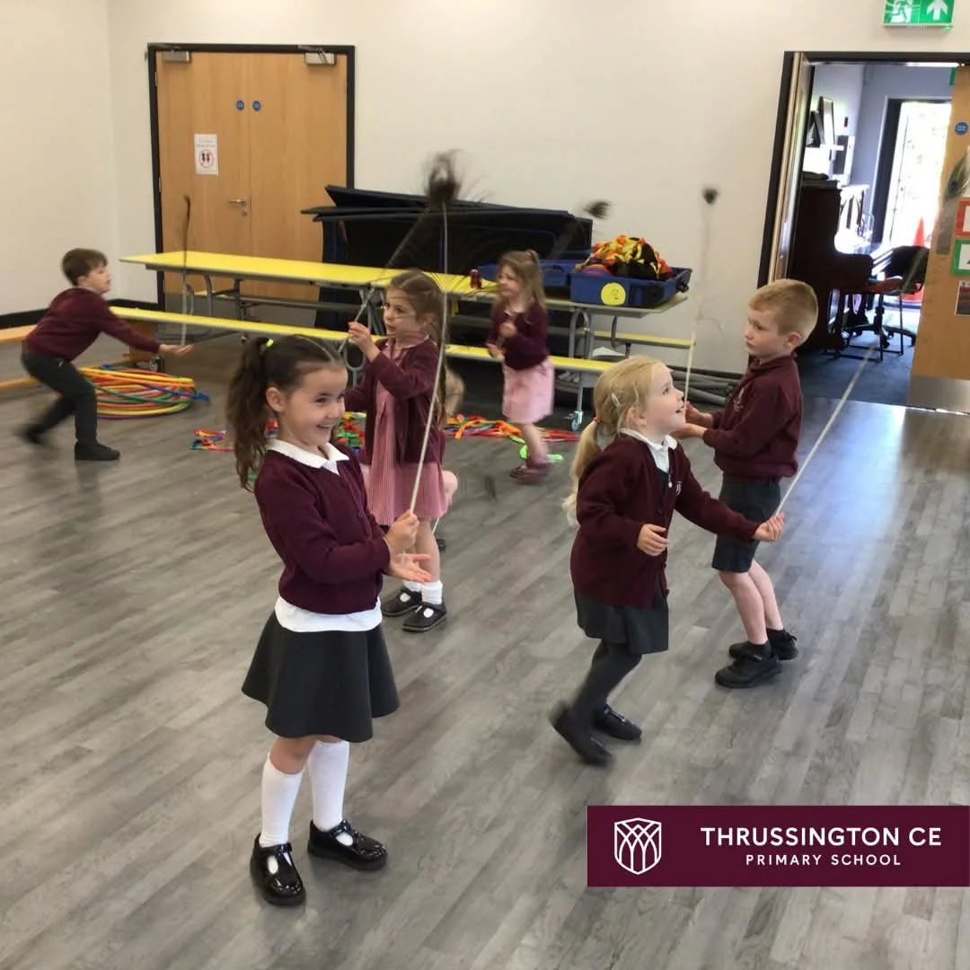 Students in a school hall practicing circus skills like feather balancing