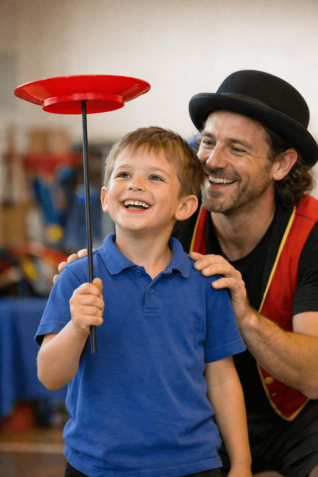 Smiling primary school child proudly spins a plate for the first time while a friendly circus instructor supports them, capturing a realistic moment of achievement, confidence, and joy.