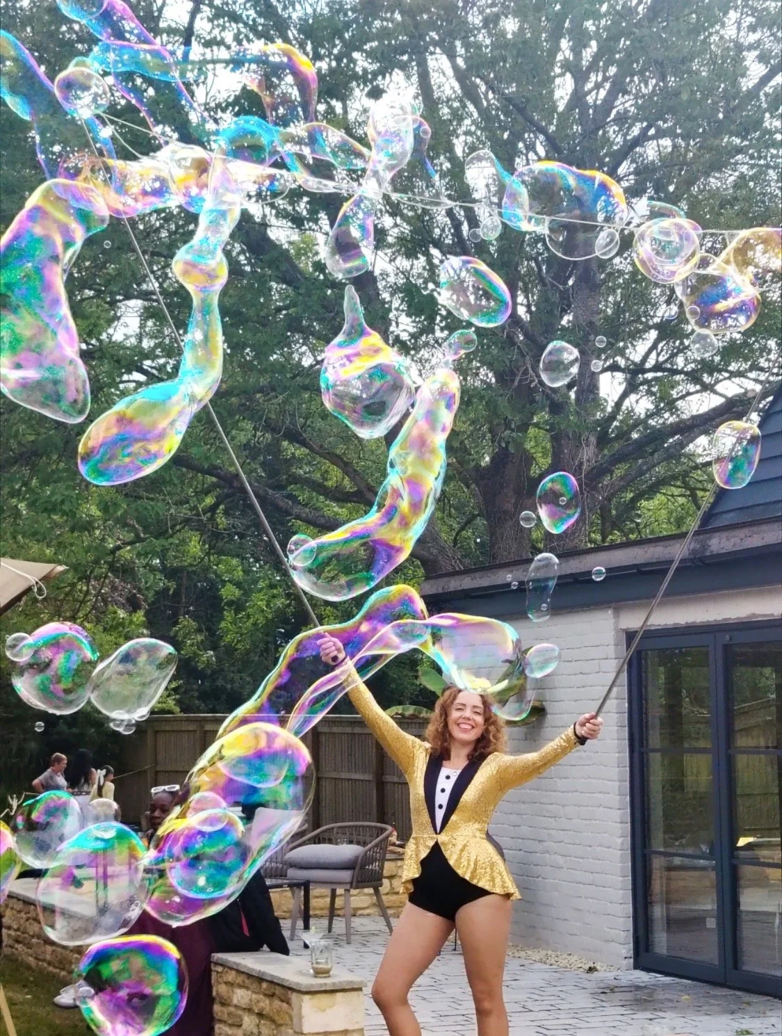 a female circus performer playing with massive bubbles at a party with Elevate Circus Workshops