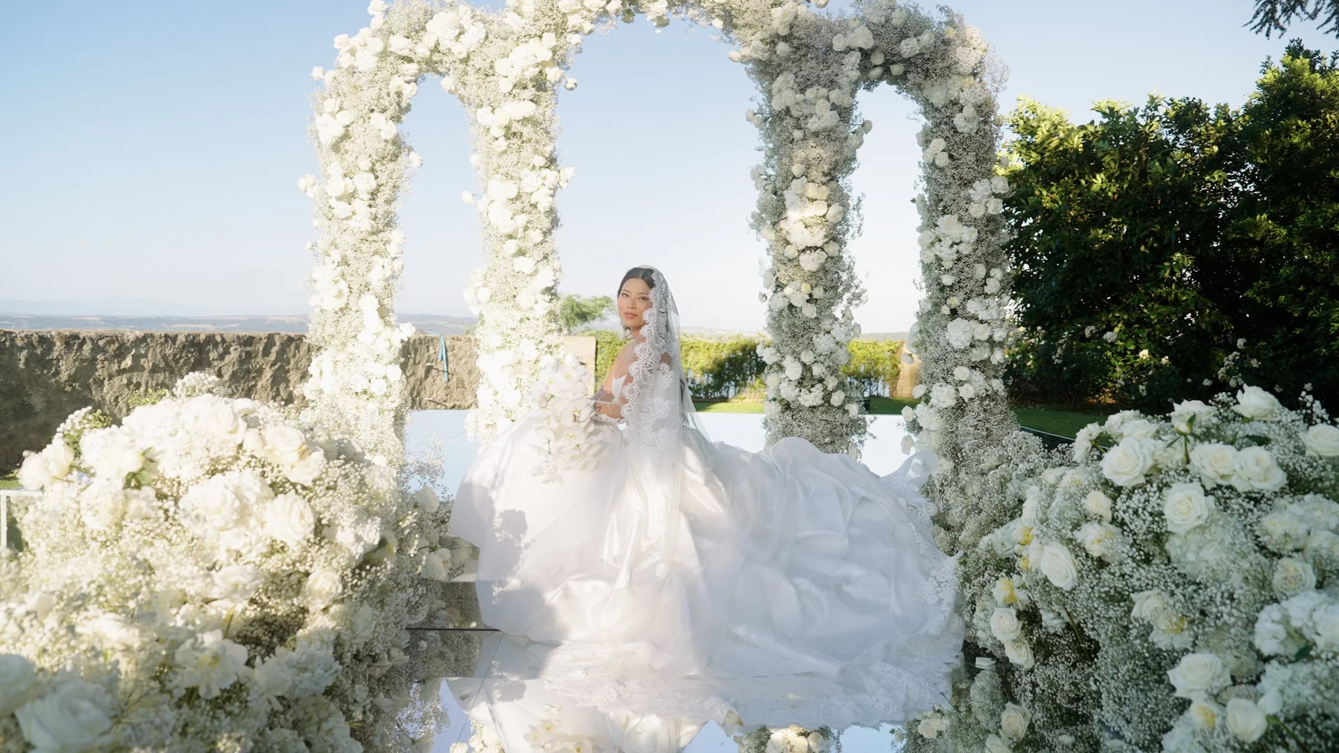 Bride standing in front of the elegant floral ceremony setup at Castello Odescalchi di Bracciano