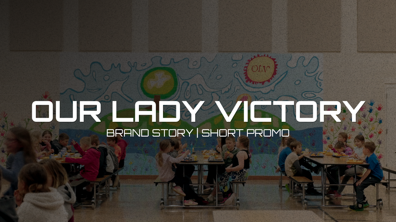 Children sitting at tables in a cafeteria with a colorful mural on the wall, celebrating victory.