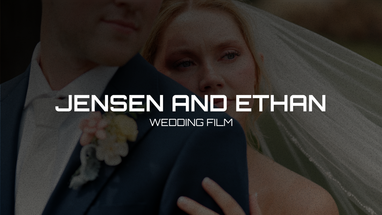 A bride and groom at their wedding, with the bride wearing a veil and the groom in a suit, outdoors.