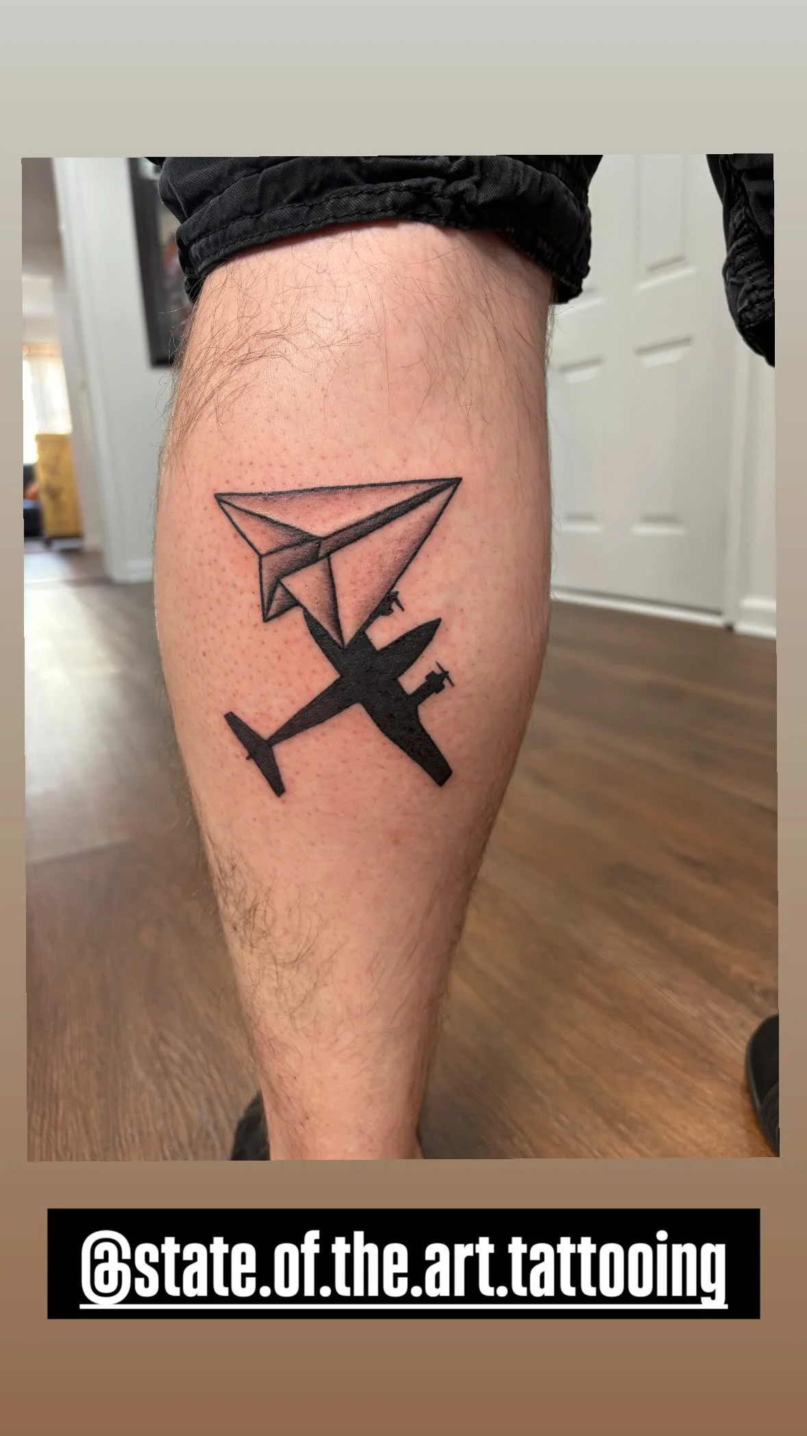 Tattoo of a paper airplane with an airplane outline below it on a person's thigh.