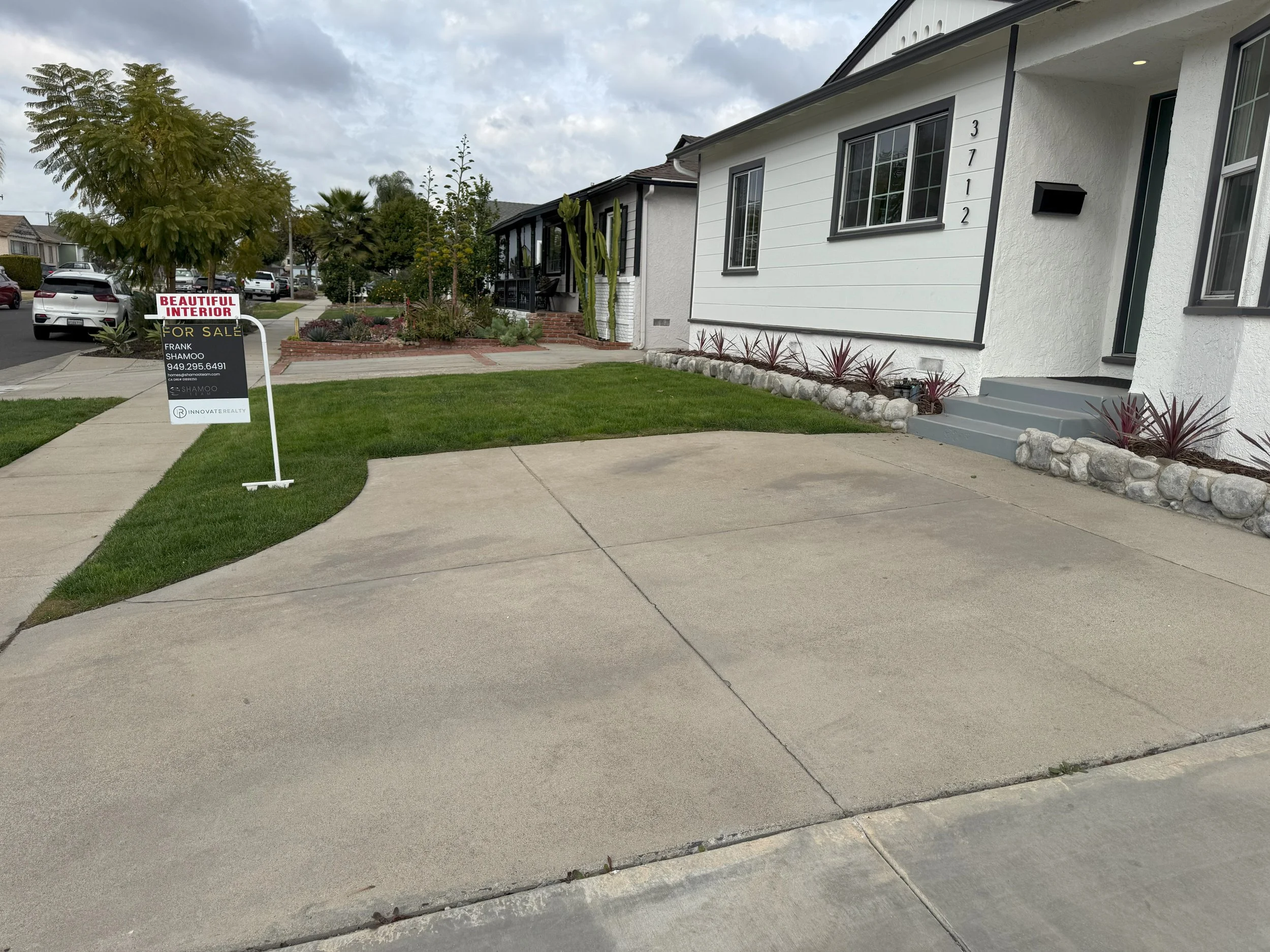 Front yard with grass lawn and too much concrete before modern desert landscape design