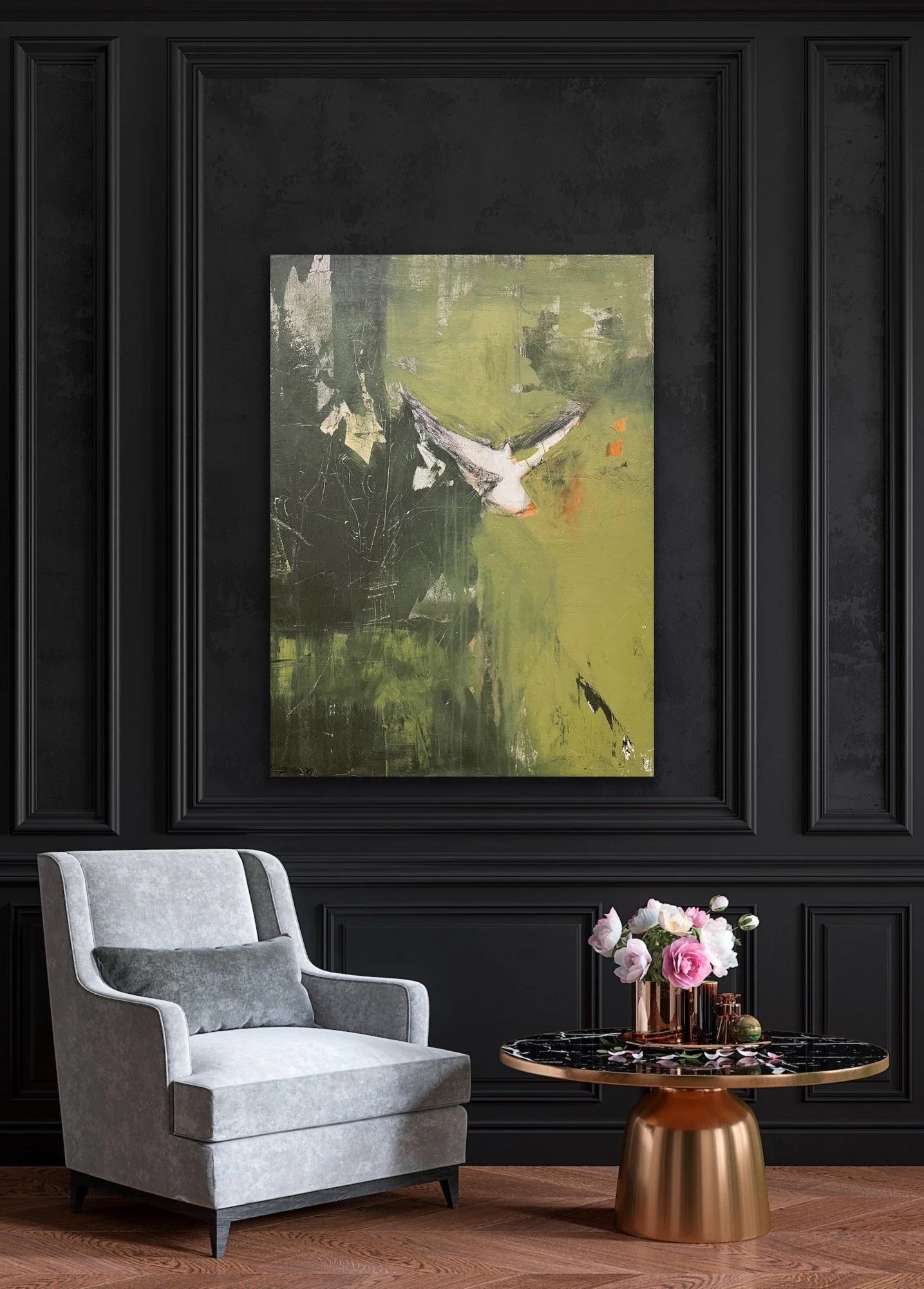 A modern interior with a dark paneled wall, a large abstract painting with green, black, white, and hints of orange, a light gray armchair with a dark gray pillow, and a round black marble table with a gold base, decorated with a pink and white flower arrangement and decorative objects.