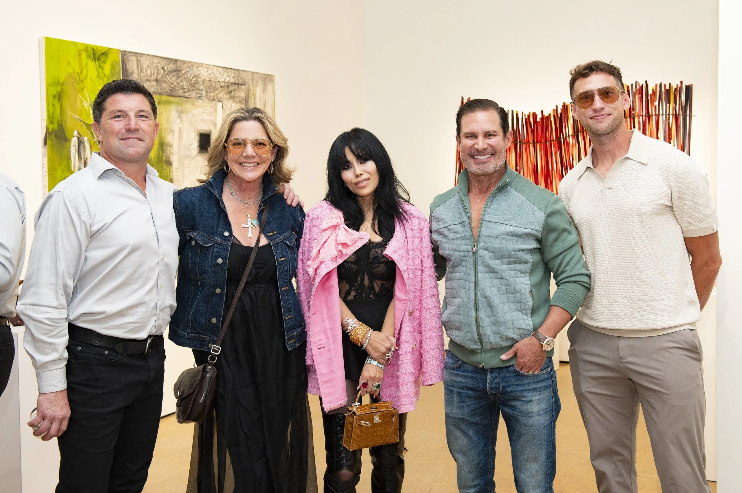 Group of six people posing together at an art gallery or museum.