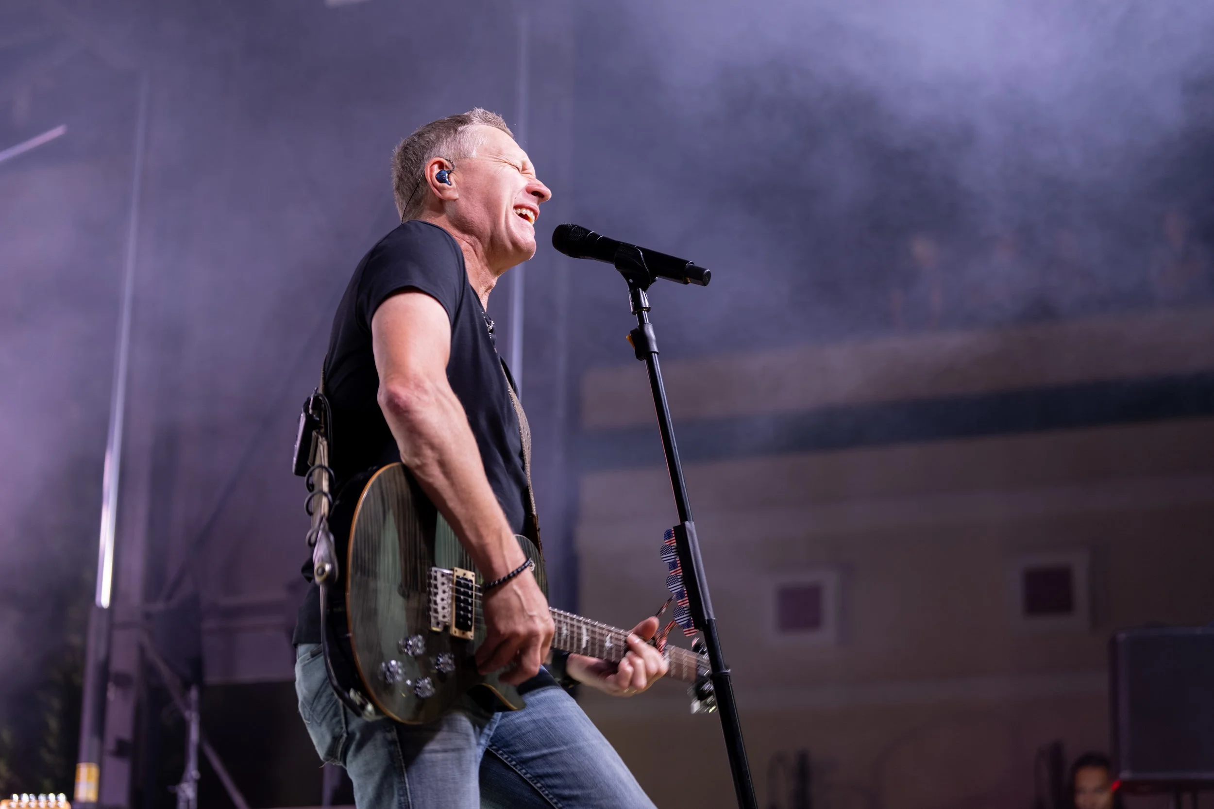 Event photography of country singer Craig Morgan singing and playing an electric guitar at a concert in Searcy Arkansas.