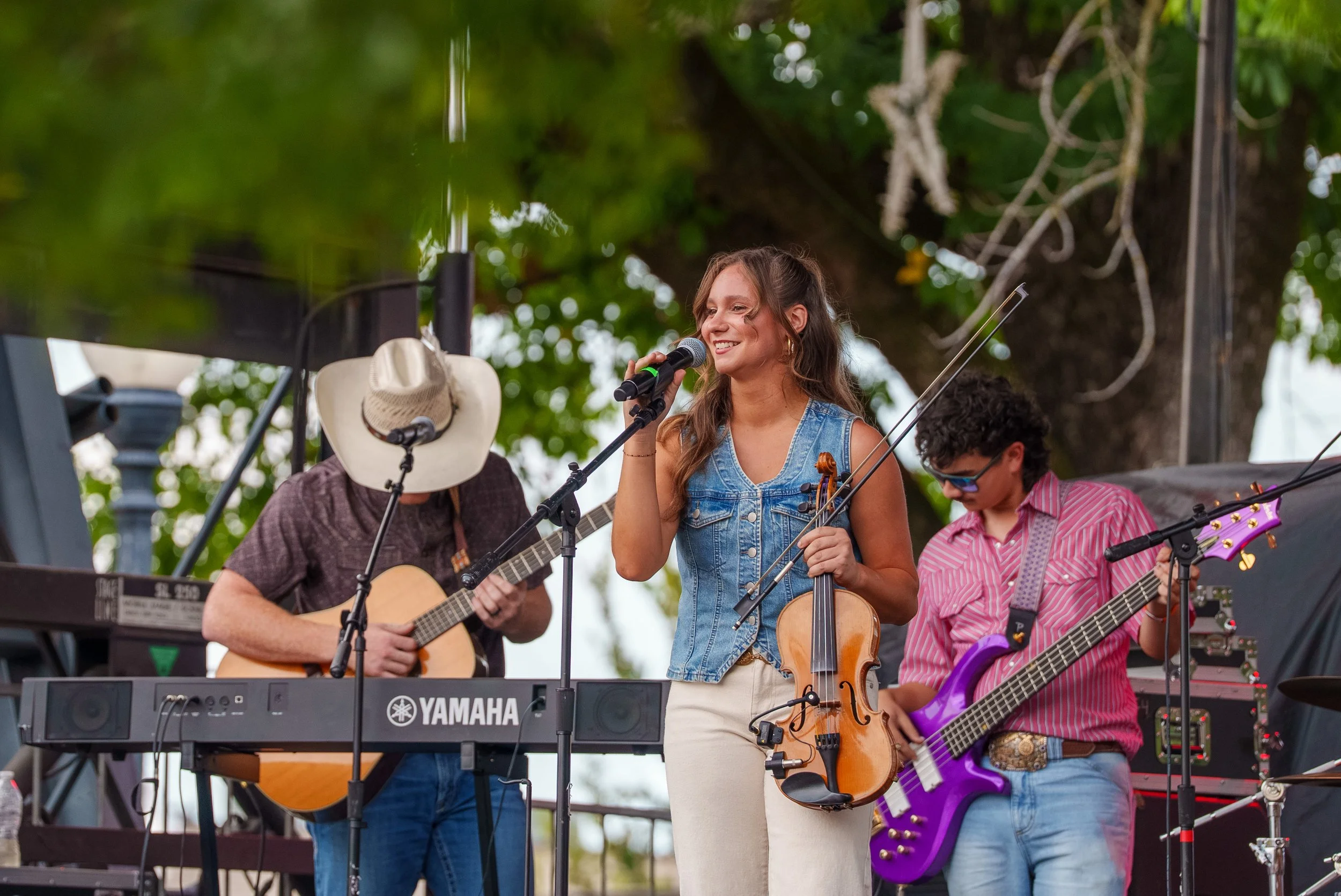 Event photography of a country singer singing and playing a instruments at a concert in Searcy Arkansas.