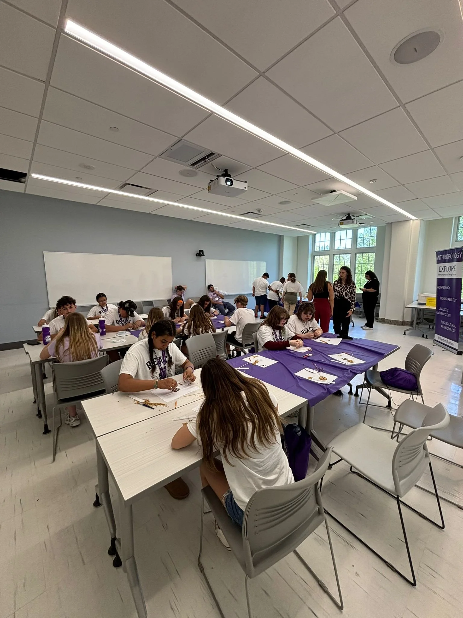 Middle school students excavating and documenting cookies like an archaeological site for the Western USC Early Outreach conference.