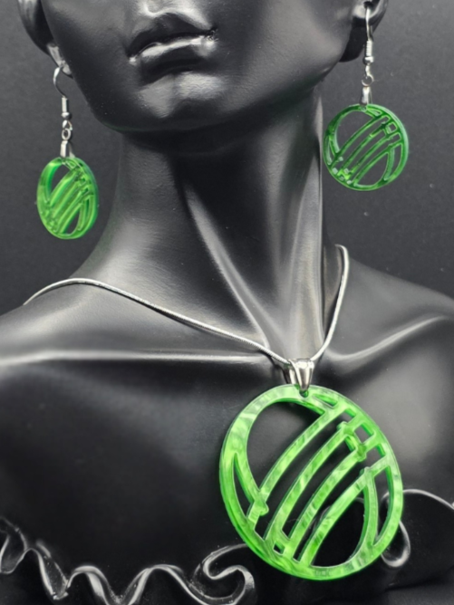 Custom earring and necklace set with translucent green circles in a striped pattern, shown on a dark display bust.
