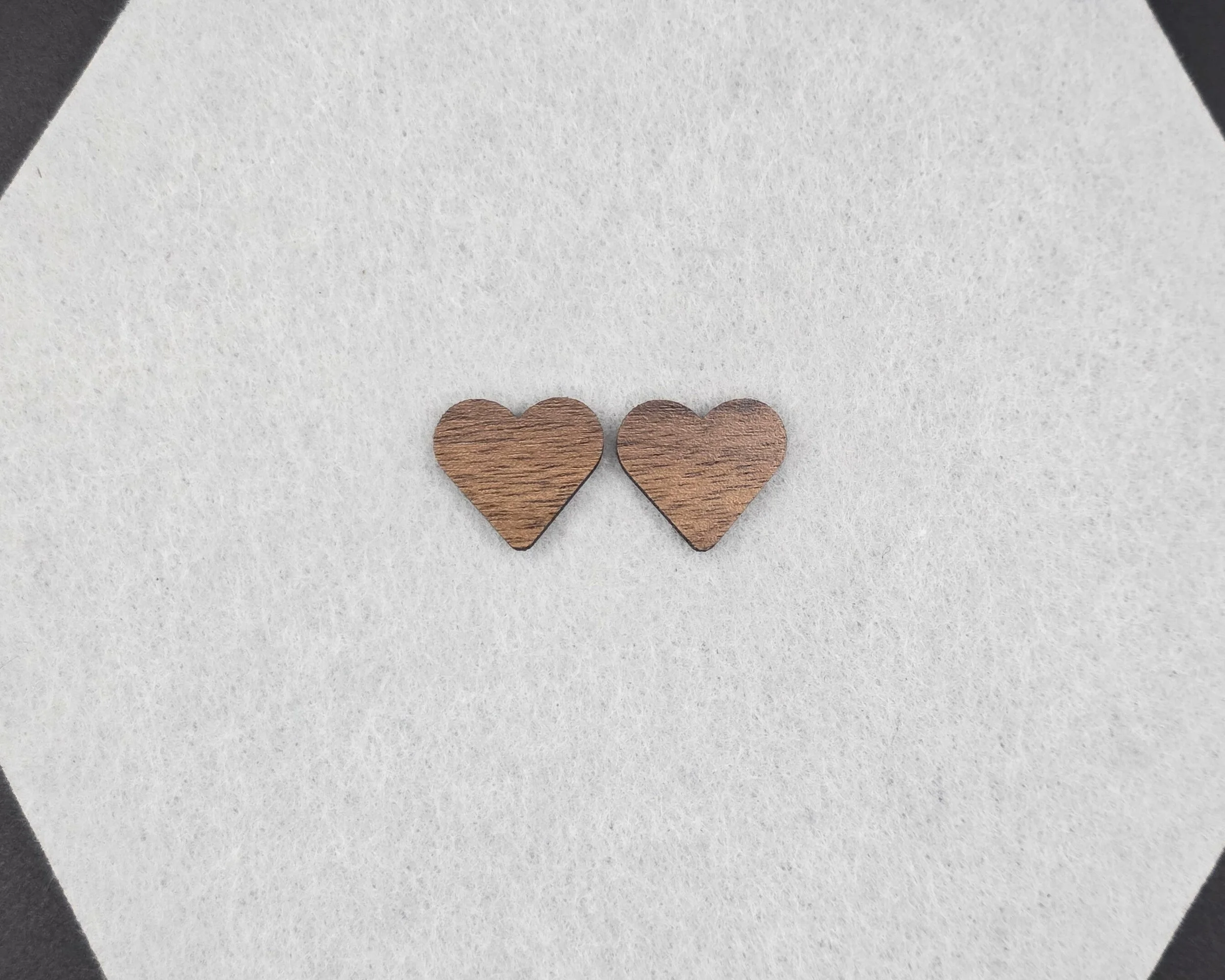 Walnut heart stud earrings on neutral felt background, handmade wood stud earrings with titanium posts
