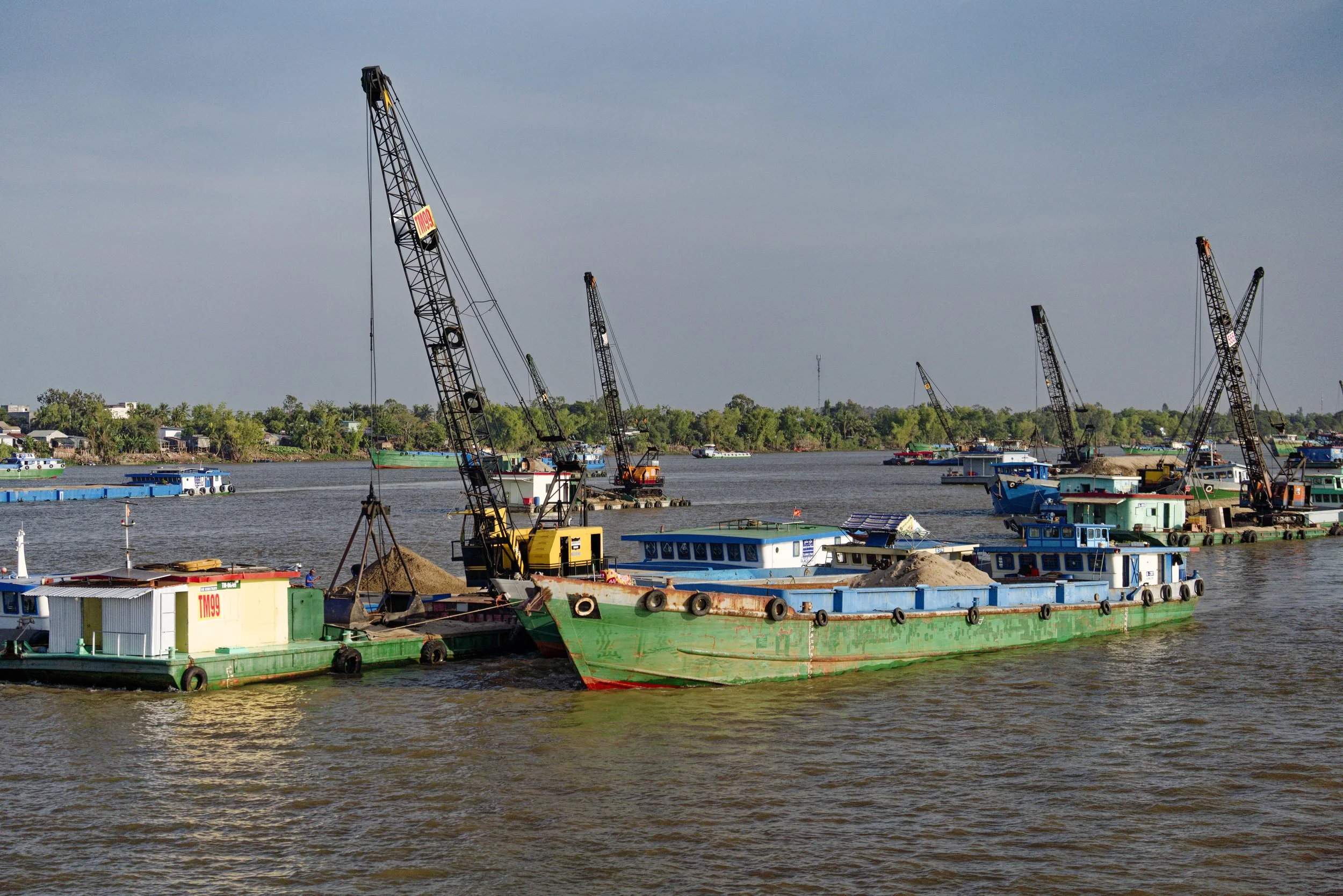 Transferring sand from Vietnam ship to Cambodian ship at the border