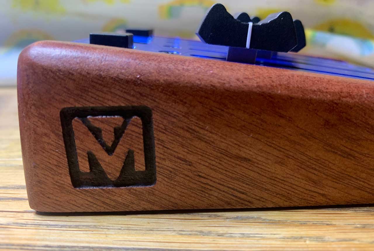 A side view of the hand-finished wood end piece of a custom programmable MIDI fader