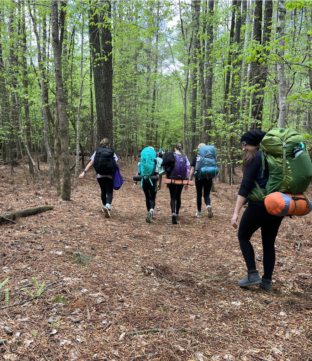 Teen girls from Troop 5117 hiking in the Outer Banks of North Carolina during a Scouts BSA backpacking trip.