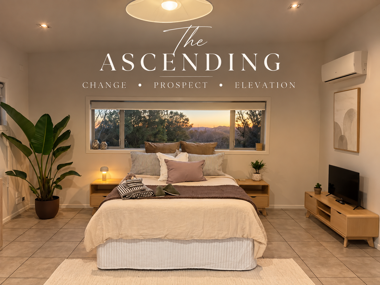 Bedroom with a neatly made bed featuring dark bedding, wooden side tables with plants, stacked towels, decorative wall alcove with sculpture, and open closet.