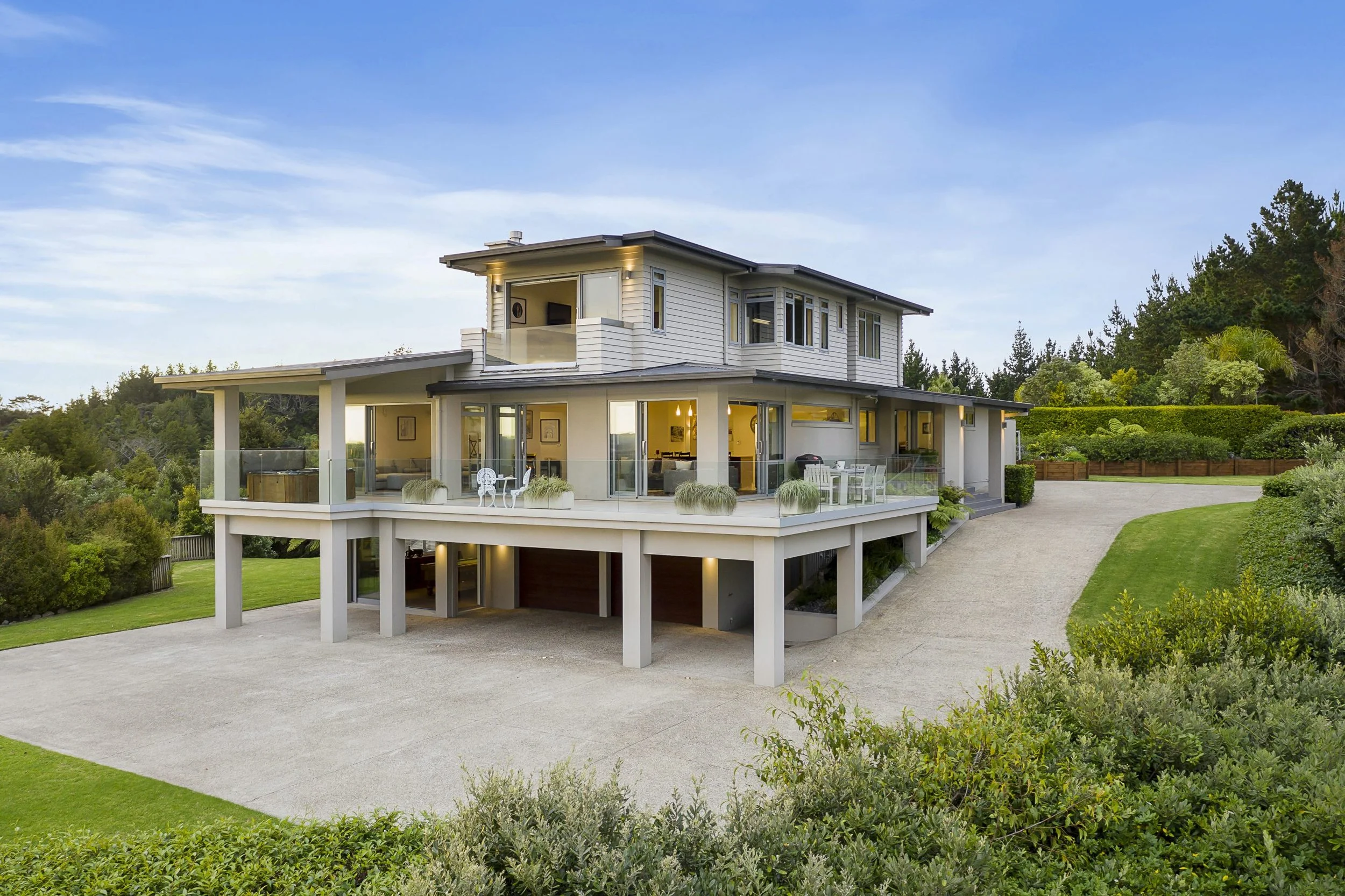 Outdoor patio with wicker furniture, a grill, and an umbrella next to a house. A grassy yard extends to the right with a fence and landscaping. A small dog is visible on the grass, at Keystone Lodge