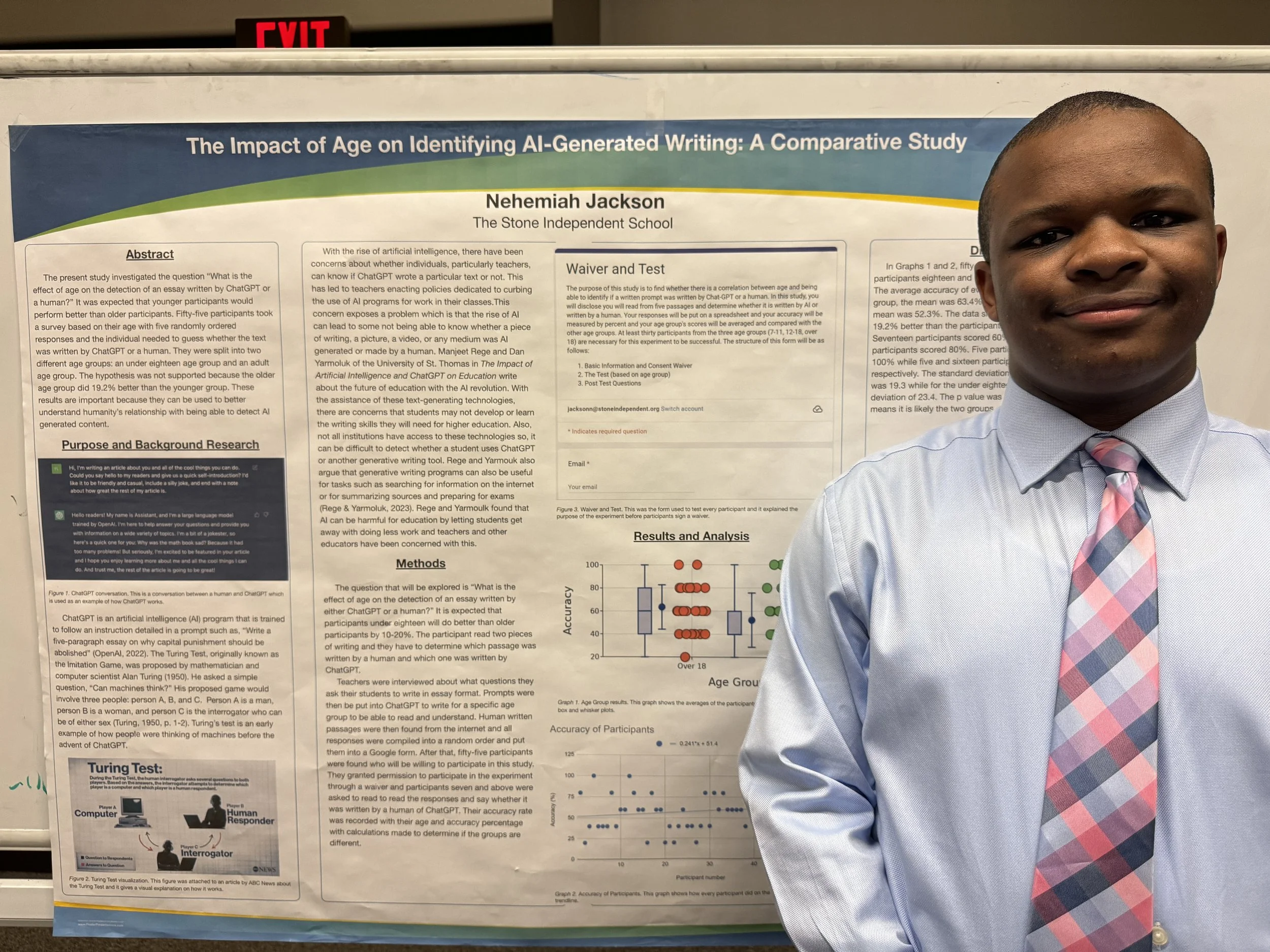 A man in a light blue dress shirt and a pink checkered tie standing next to a research poster titled 'The Impact of Age on Identifying AI-Generated Writing: A Comparative Study'. The poster contains sections with text, graphs, and images related to t