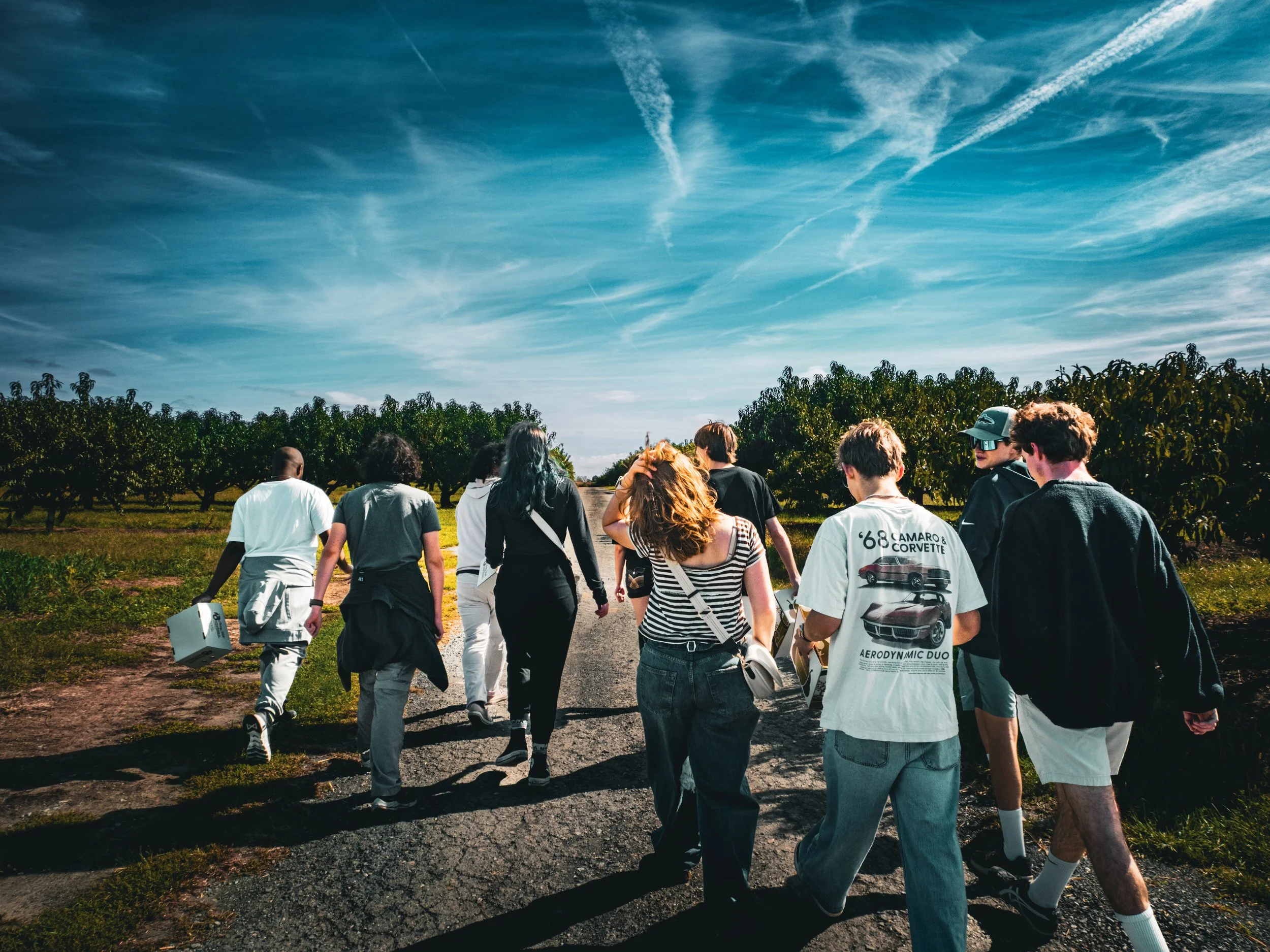Group of people gathered around a table with a large map, discussing and pointing at various locations.
