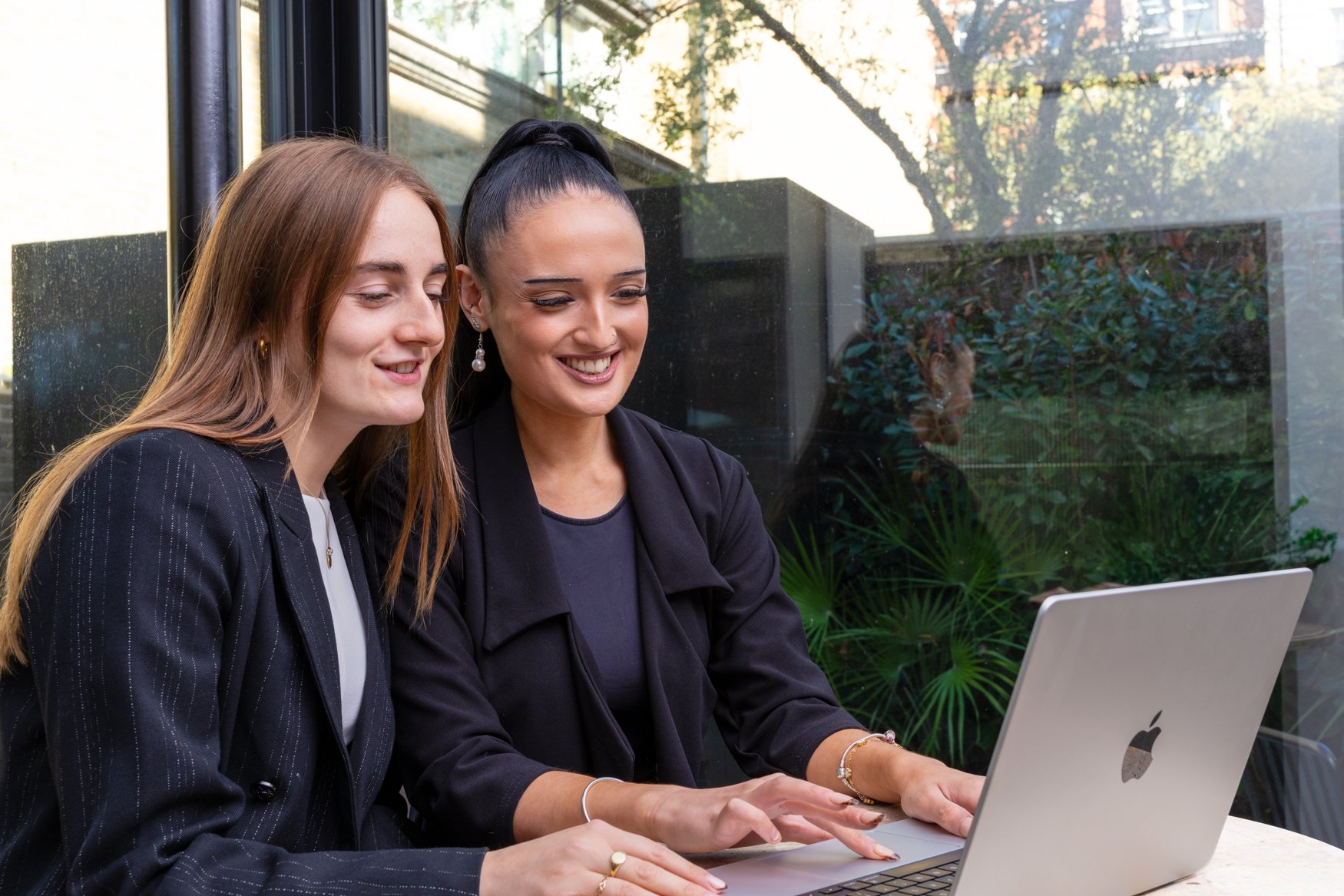On-location corporate photography of two colleagues at a laptop in a London office