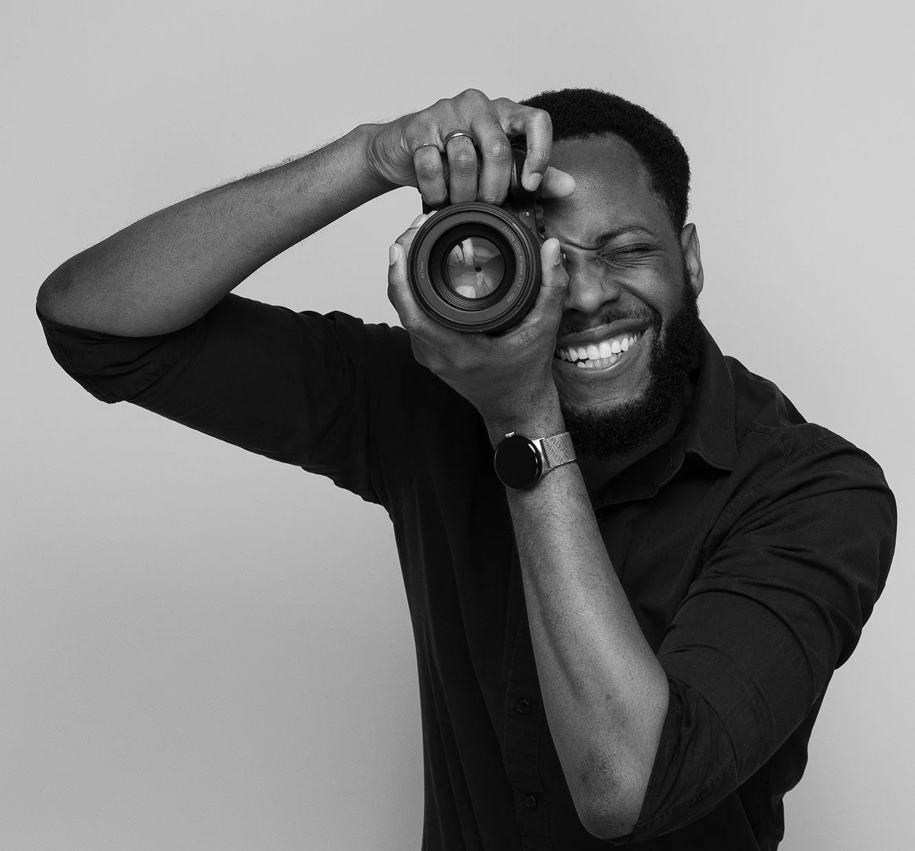 Andrew, LinkedIn headshot photographer London, gripping his camera in a black and white editorial portrait — Shot By Andrew, professional headshot photographer London