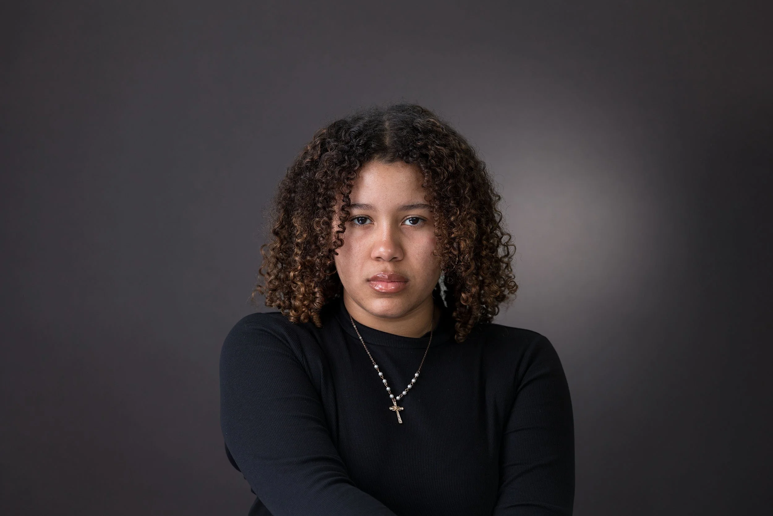Female actor headshot London. Dramatic theatrical look, intense natural expression, dark neutral background, shot by Andrew