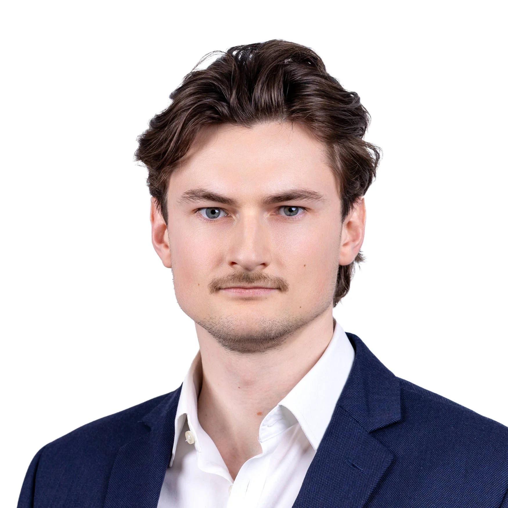 Young man in white shirt but blue suit jacket taking part in a business headshot on a white backdrop, taken on location on Regent Street, Mayfair