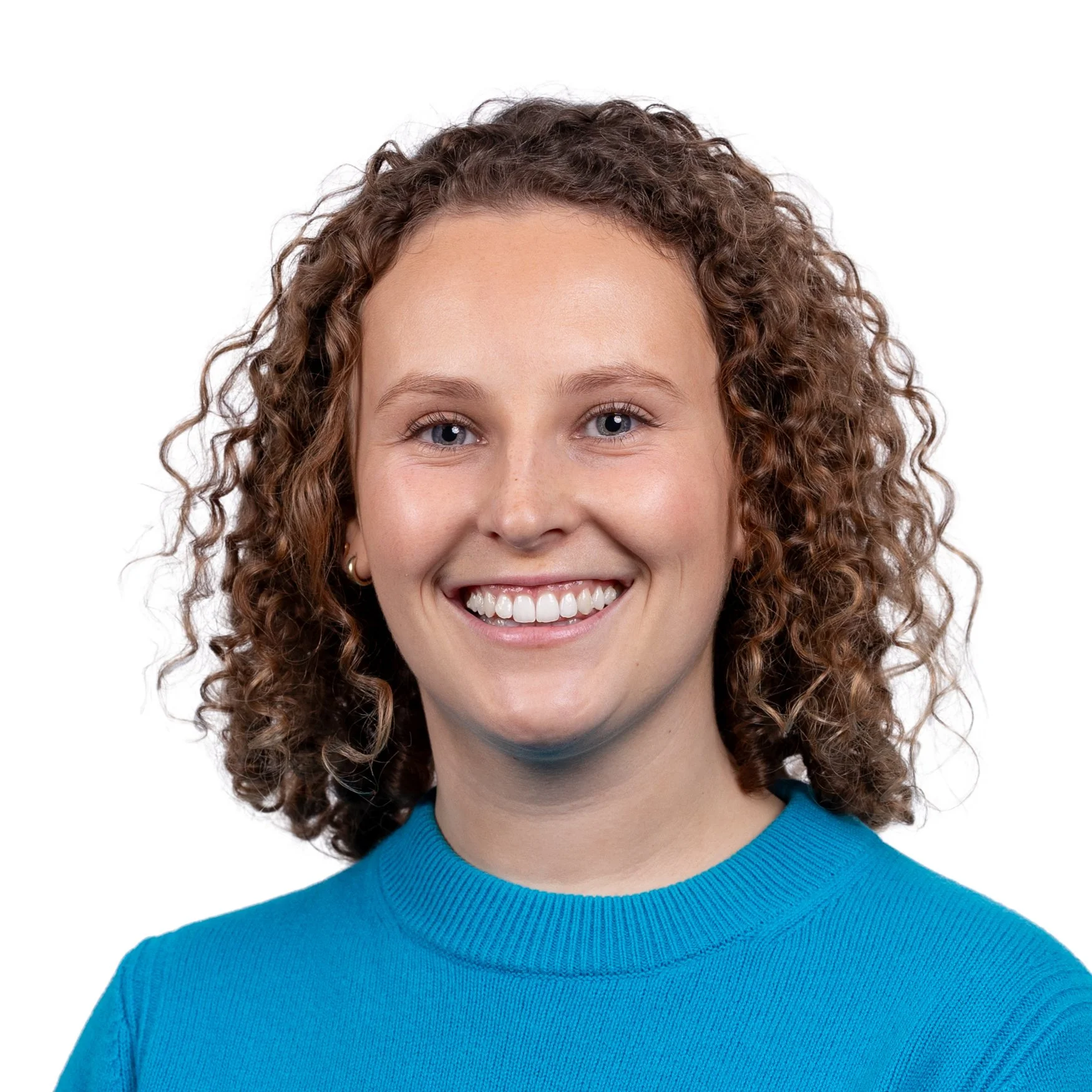 Woman with curly hair and wearing a blue jumper taking part in a corporate headshot on a white backdrop for a real estate investment company on Regent Street, Mayfair