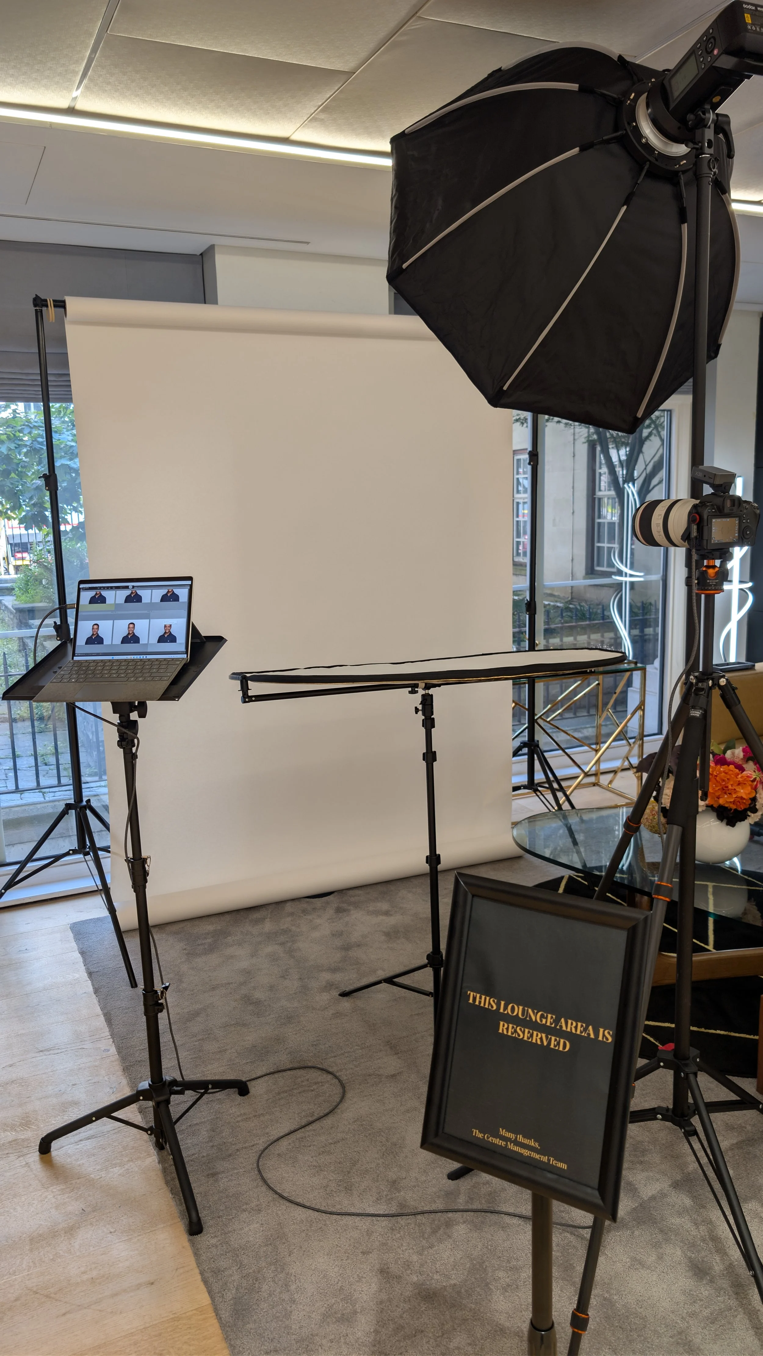 Portable headshot studio in an office corner with an octabox softbox, pale backdrop and tethering laptop | On-location corporate headshots London | Shot By Andrew