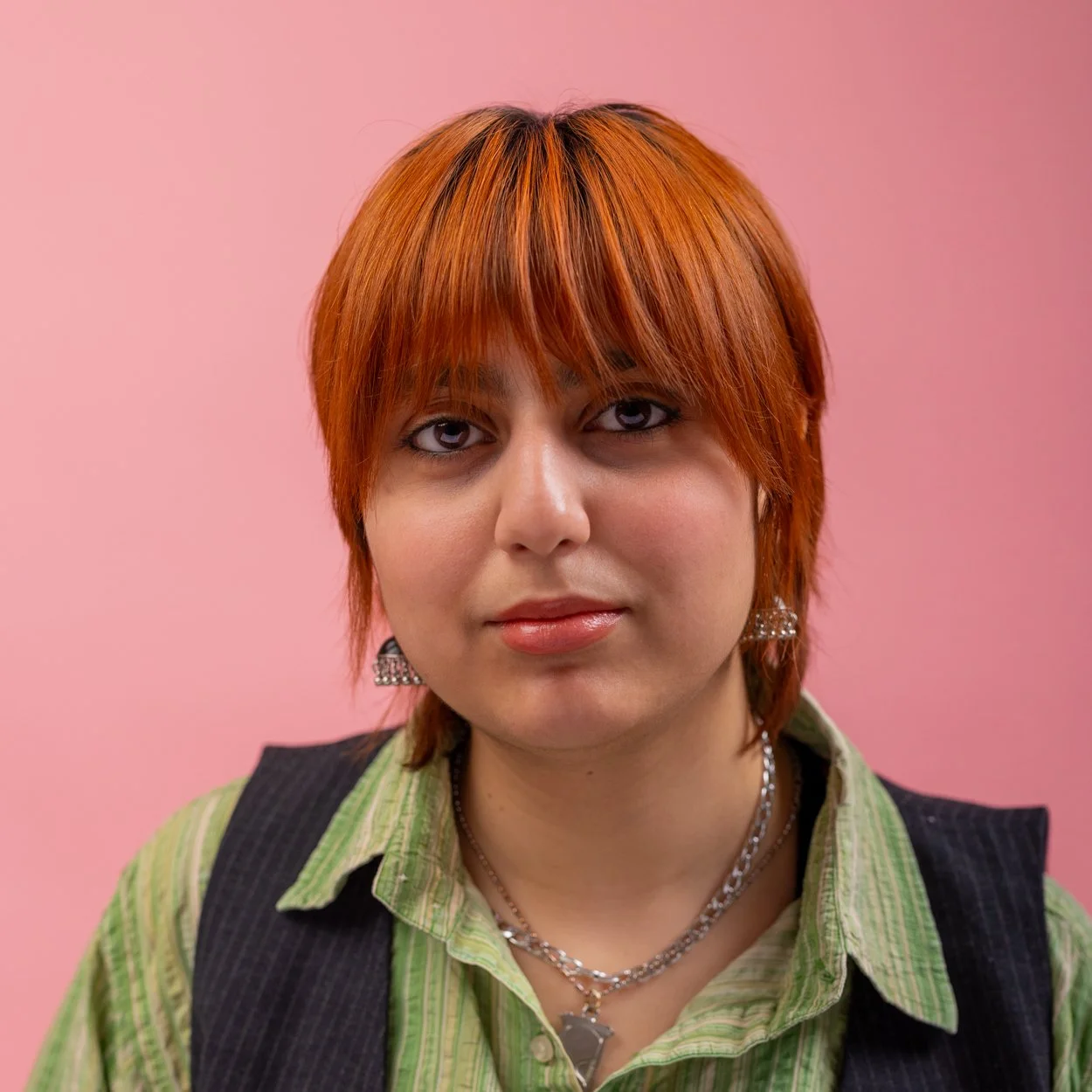 Woman with orange hair, in a green stripy shirt and black waist coat - Director headshot for an independent filmmaker's website, London