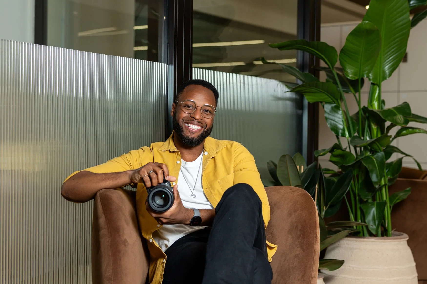 Shot By Andrew, a London corporate photographer, holding his camera in a modern office