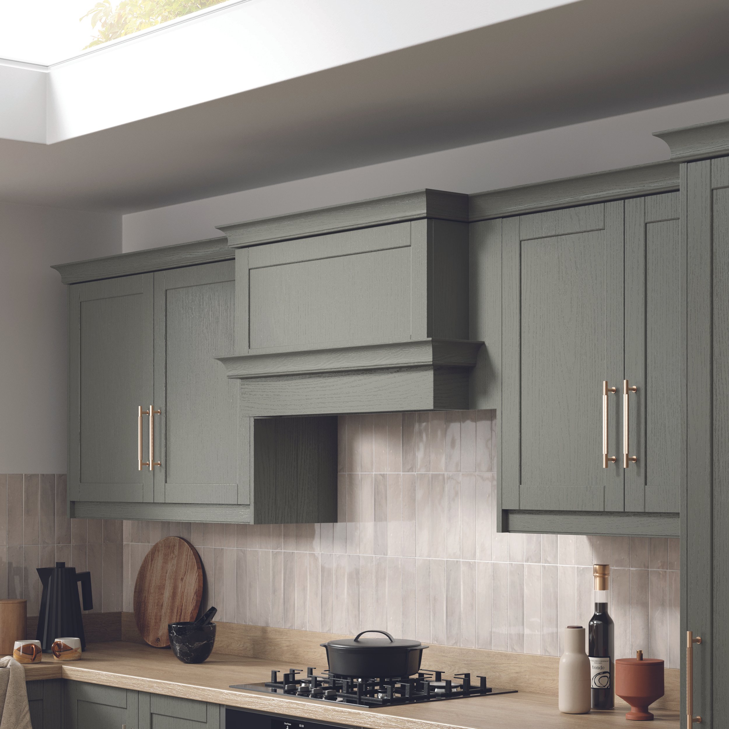 Modern kitchen with green cabinets, wooden countertop, black stove, and a tiled backsplash. Accessories include bottles, cups, a cutting board, and a pot.