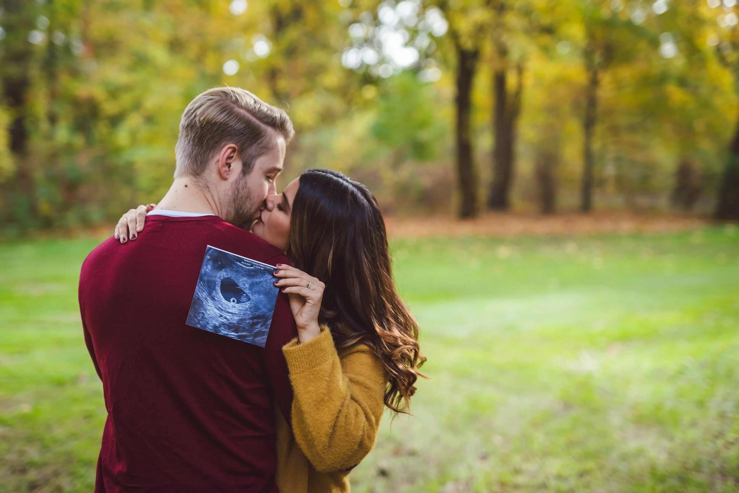 Two young children, a boy and a girl, running and smiling at a celebration with gold and white balloons in the background.