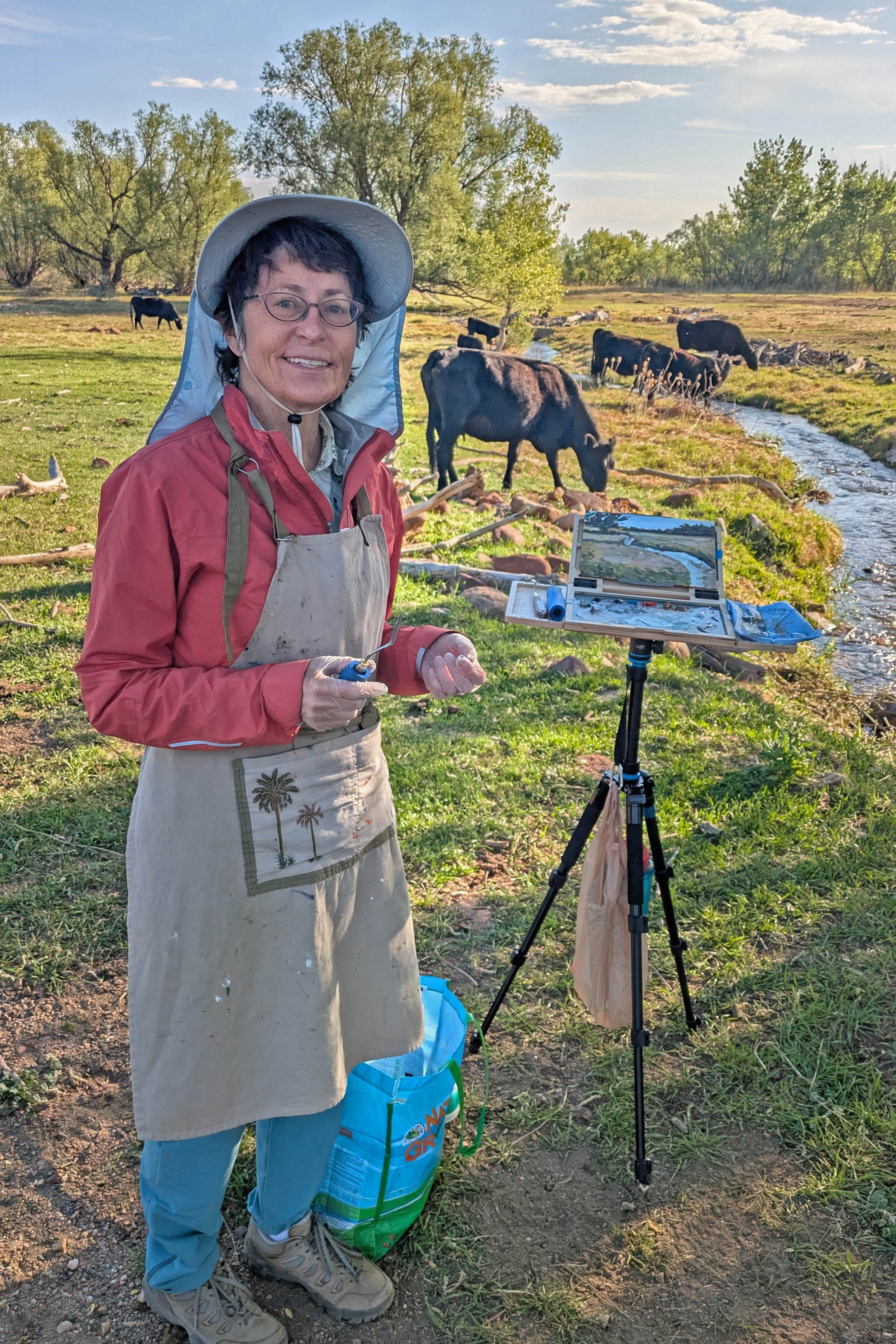 Lisa standing by her easel with cows