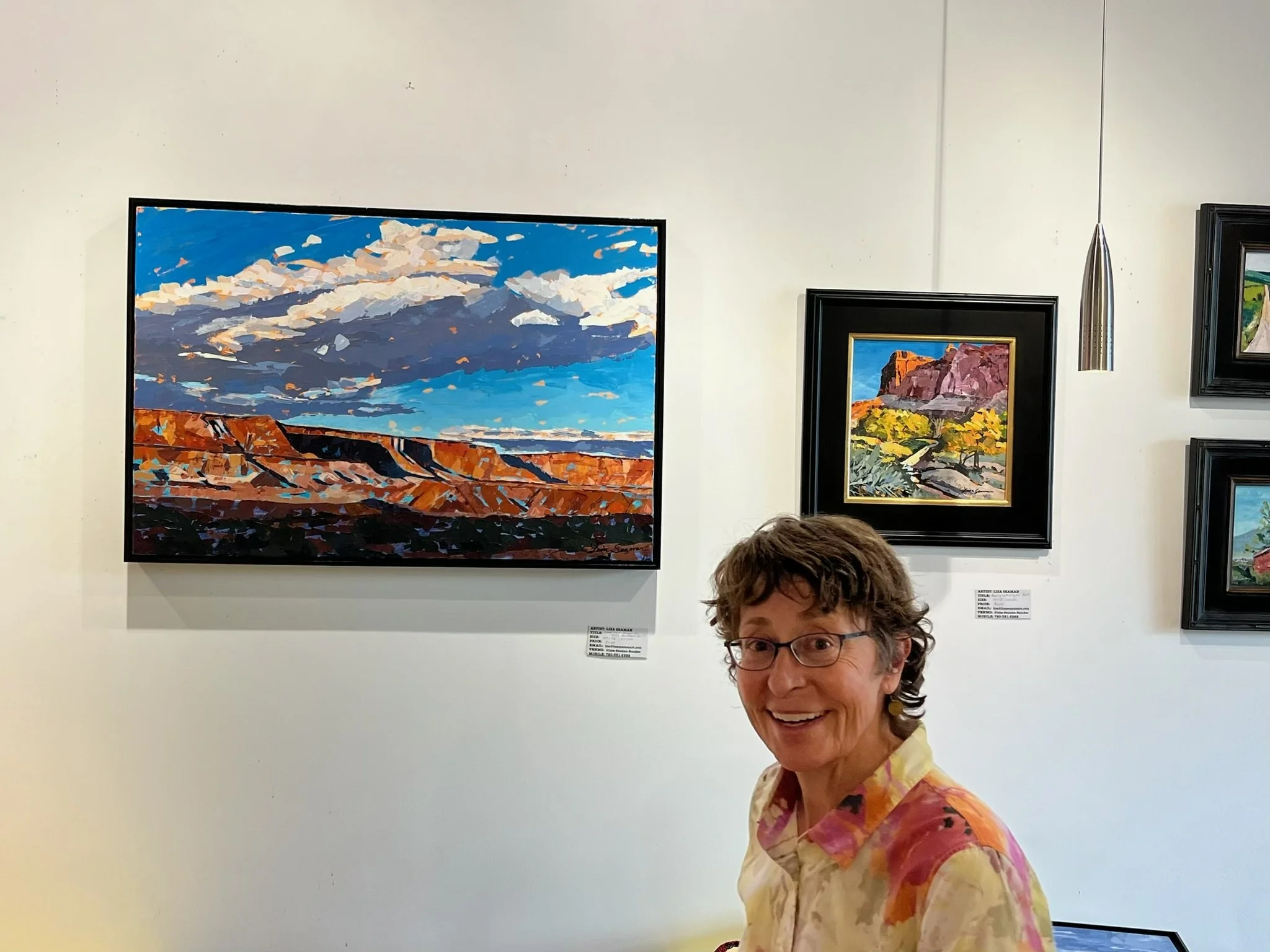 Lisa in front of paintings at Spruce Cafe