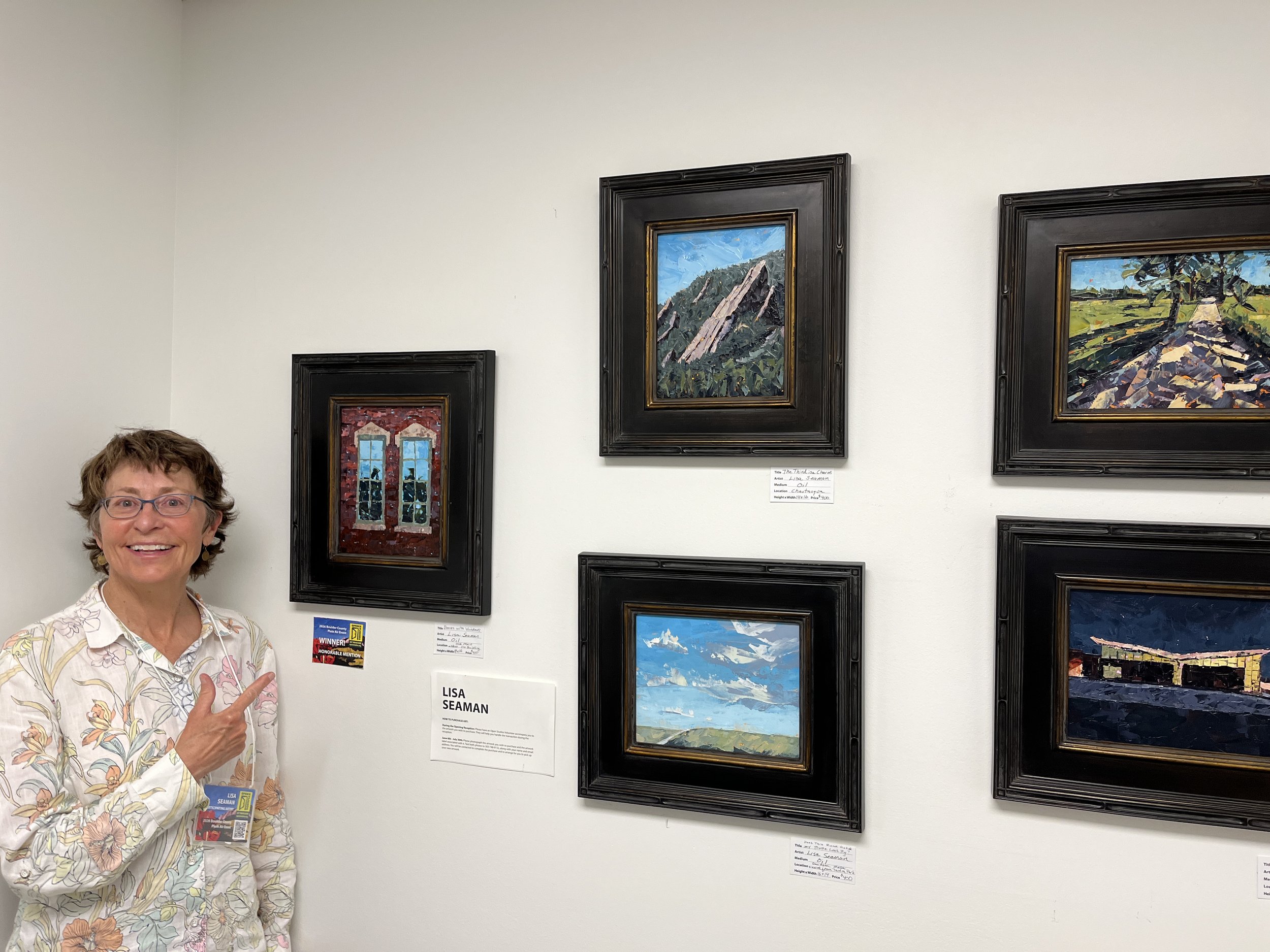 Lisa standing by her five paintings