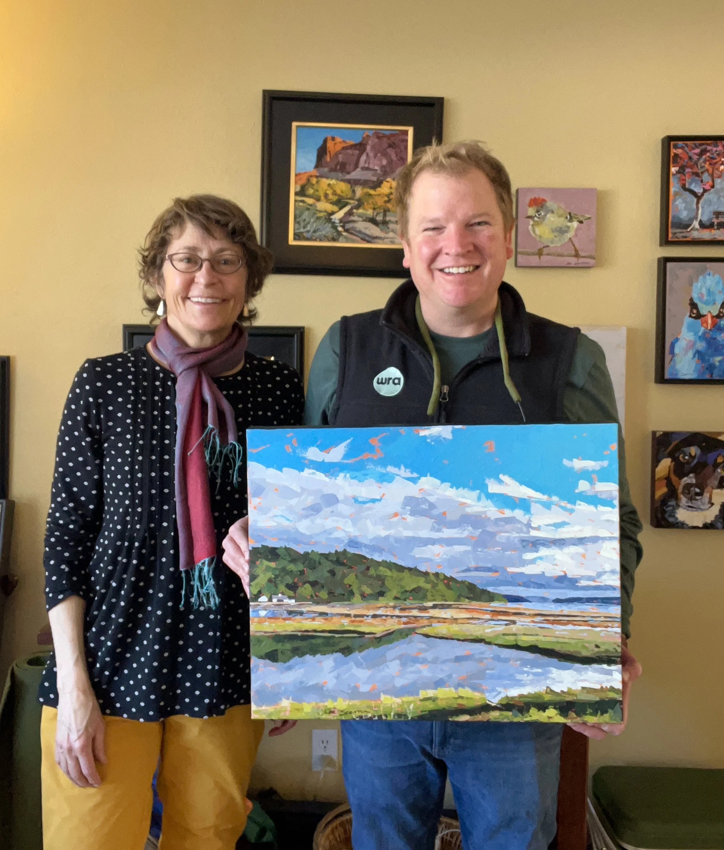 Lisa and John hold a painting