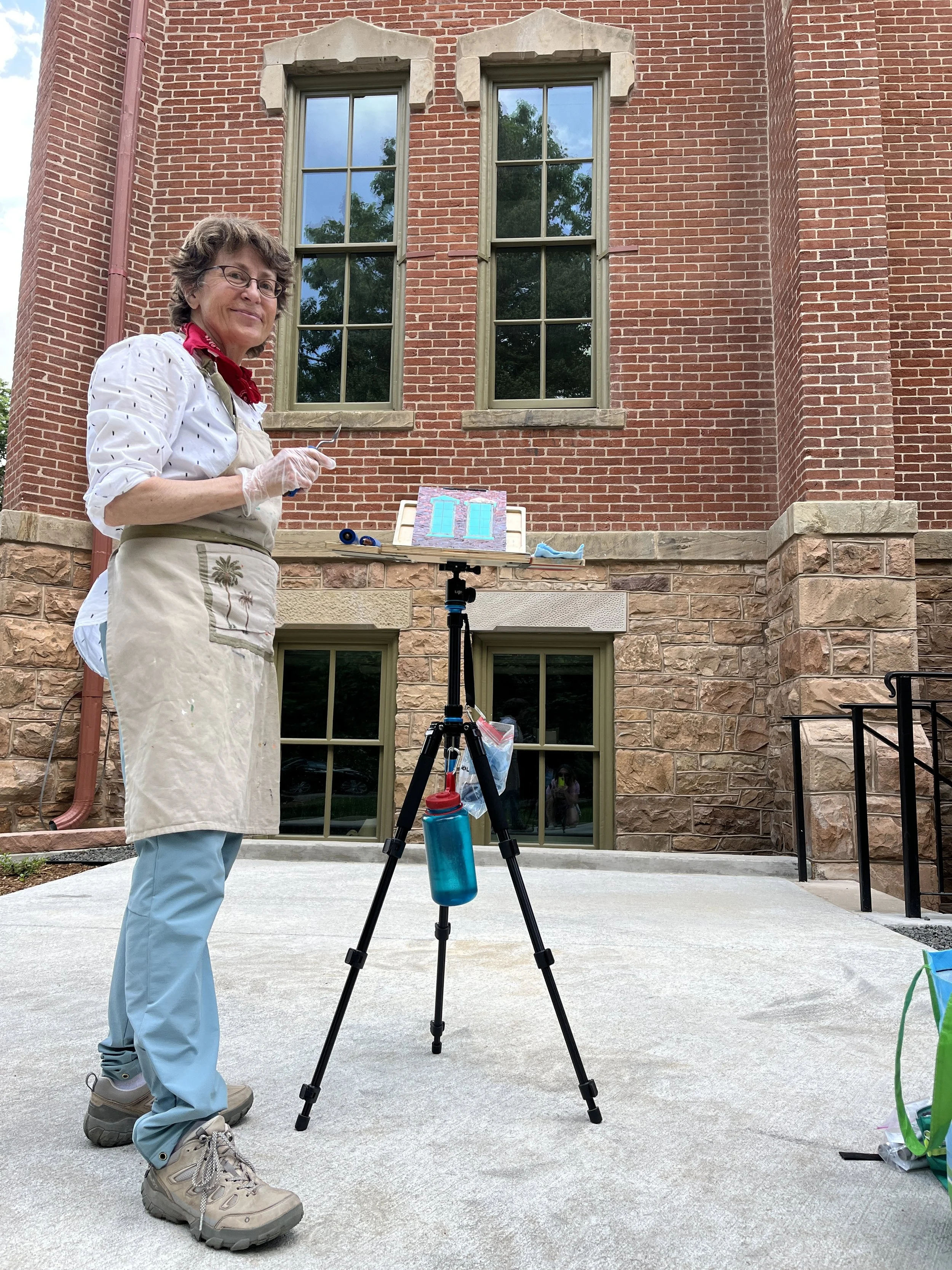Lisa painting two windows of Old Main building at CU.