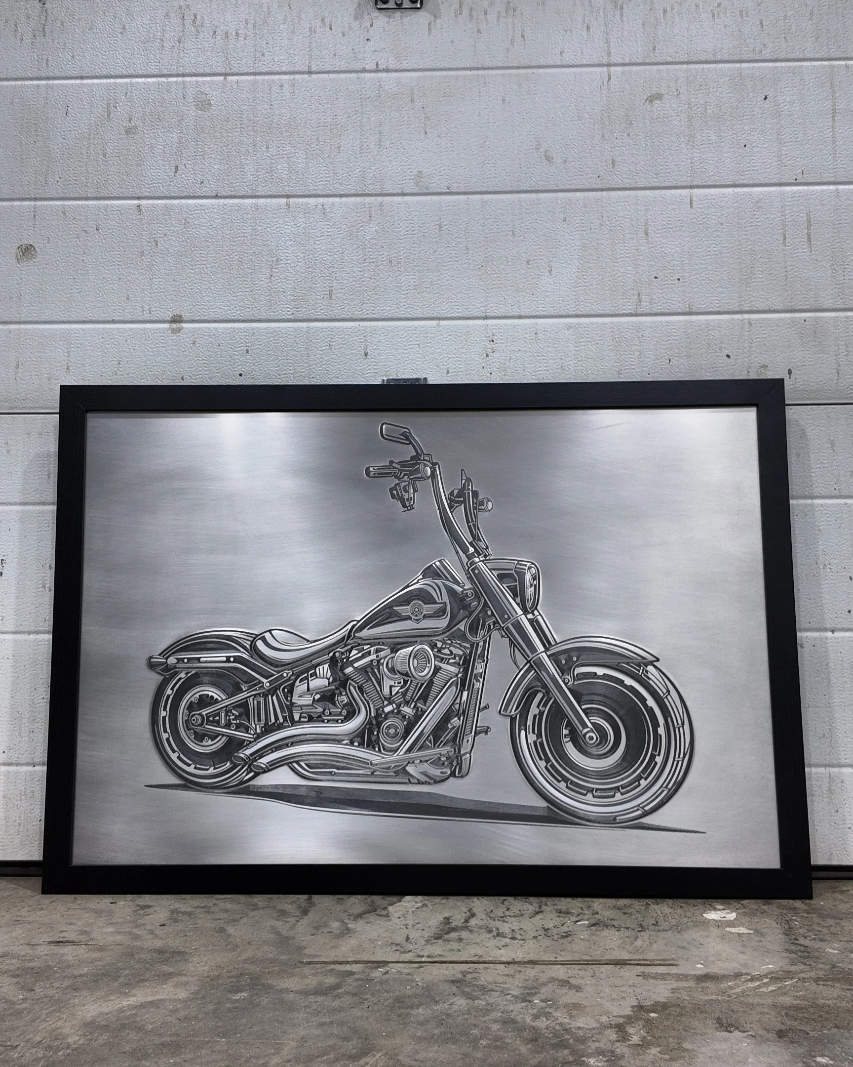 Framed black and white illustration of a motorcycle on a wall.