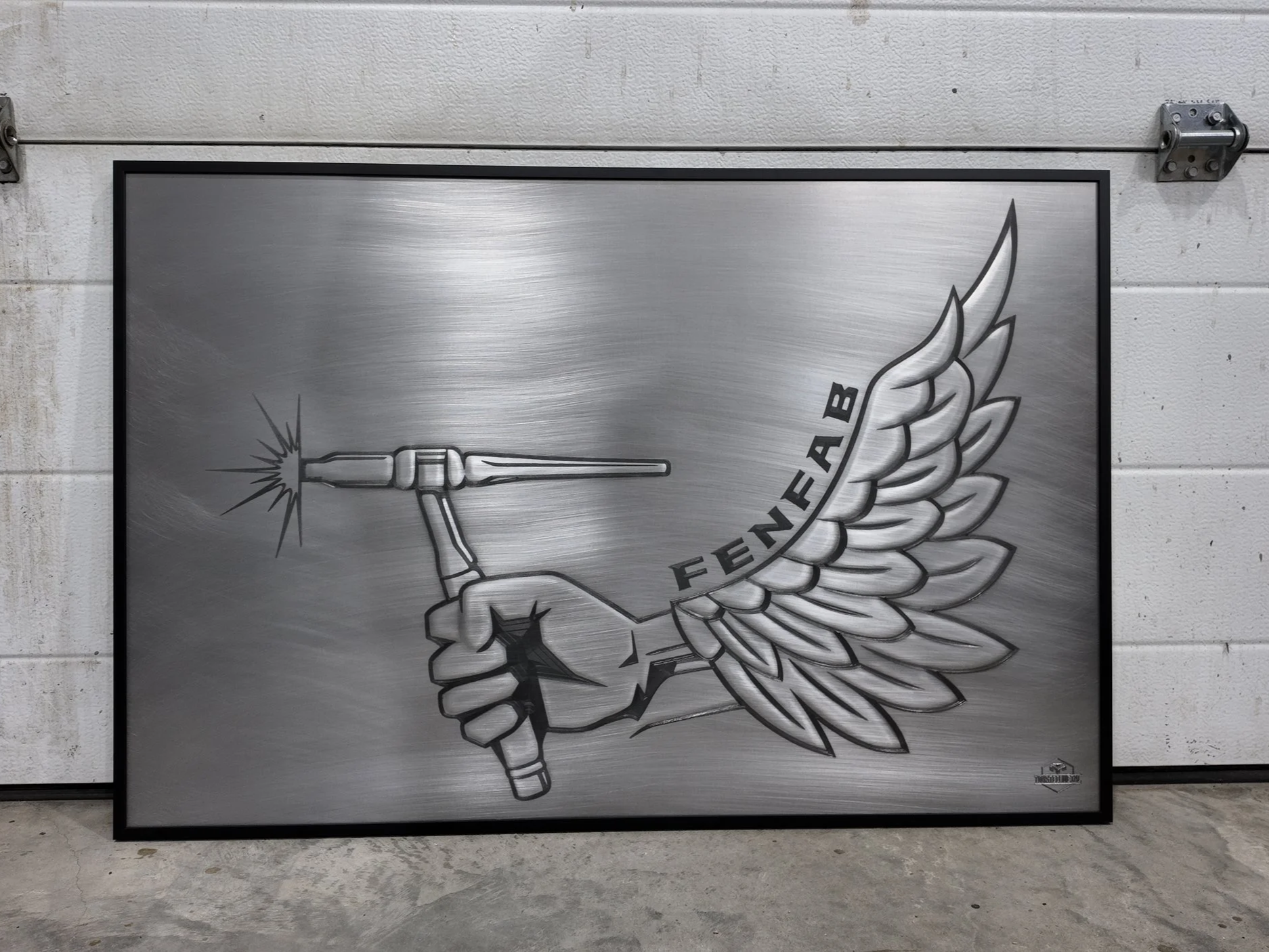 A metallic sign with a graphic of a hand holding a sparkler, wings attached to the hand, and the word "FENAB" written on the wing.