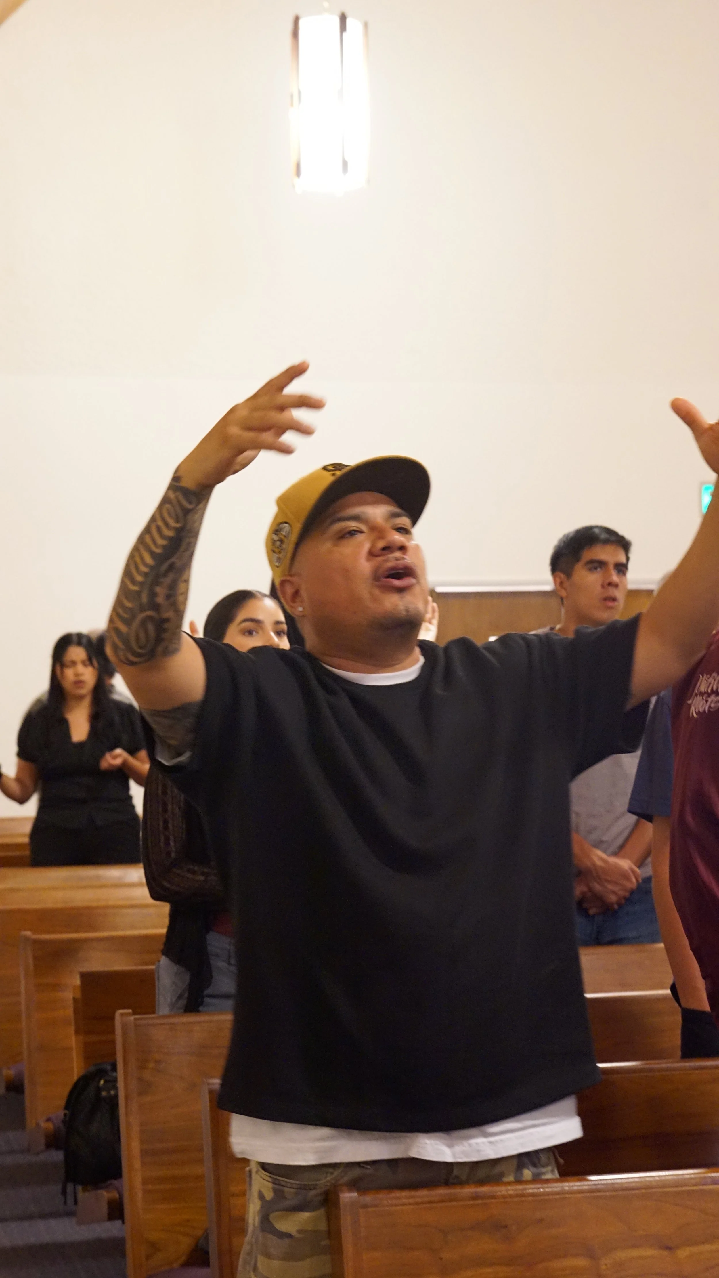 A man worshipping with raised hands at Home Church San Diego.
