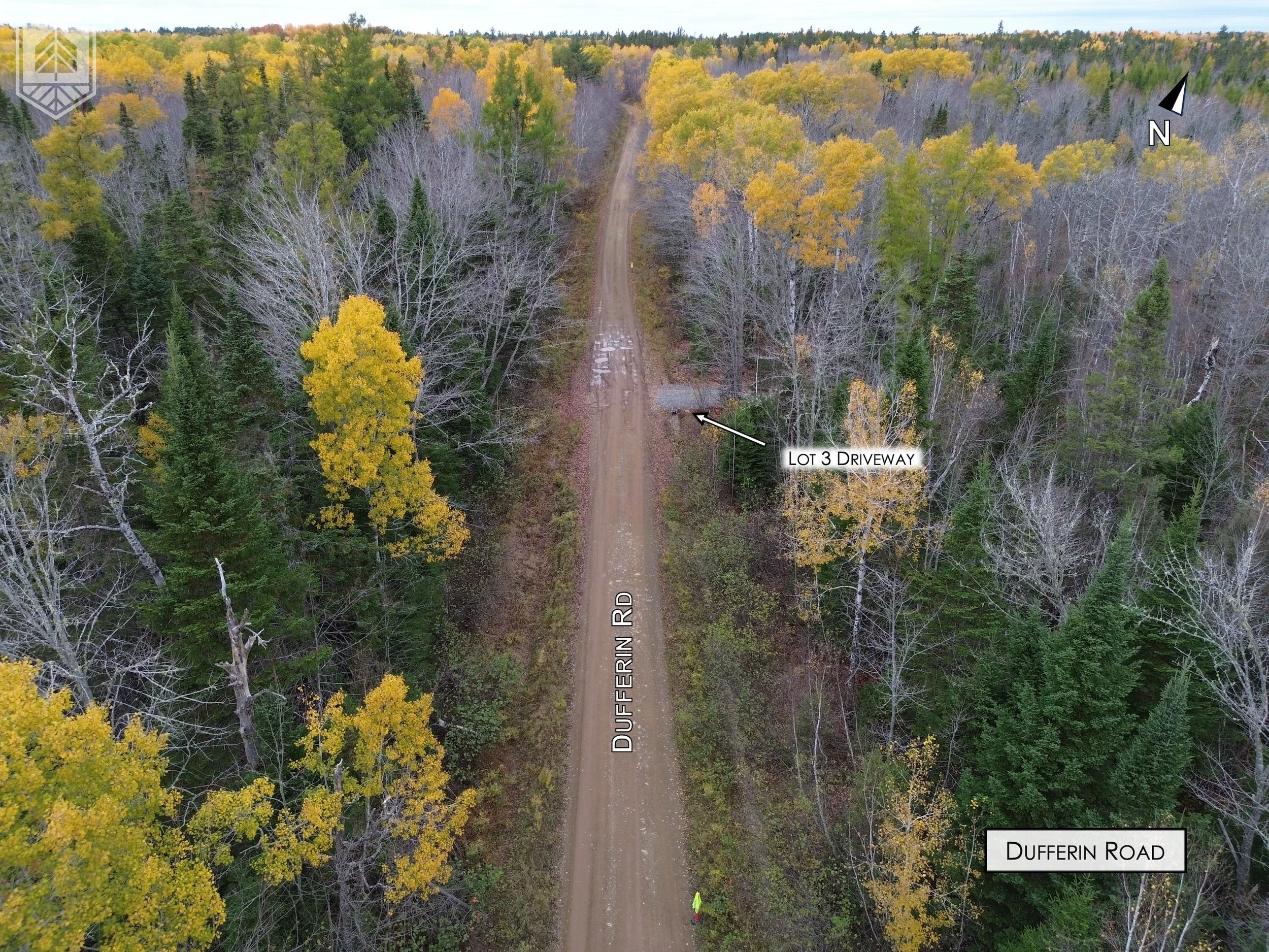 Aerial view of a dirt road called Dufferin Road running through a forest with trees in fall colors and some trees without leaves. A driveway labeled 'Lot 3 Driveway' branches off from Dufferin Road on the right side.