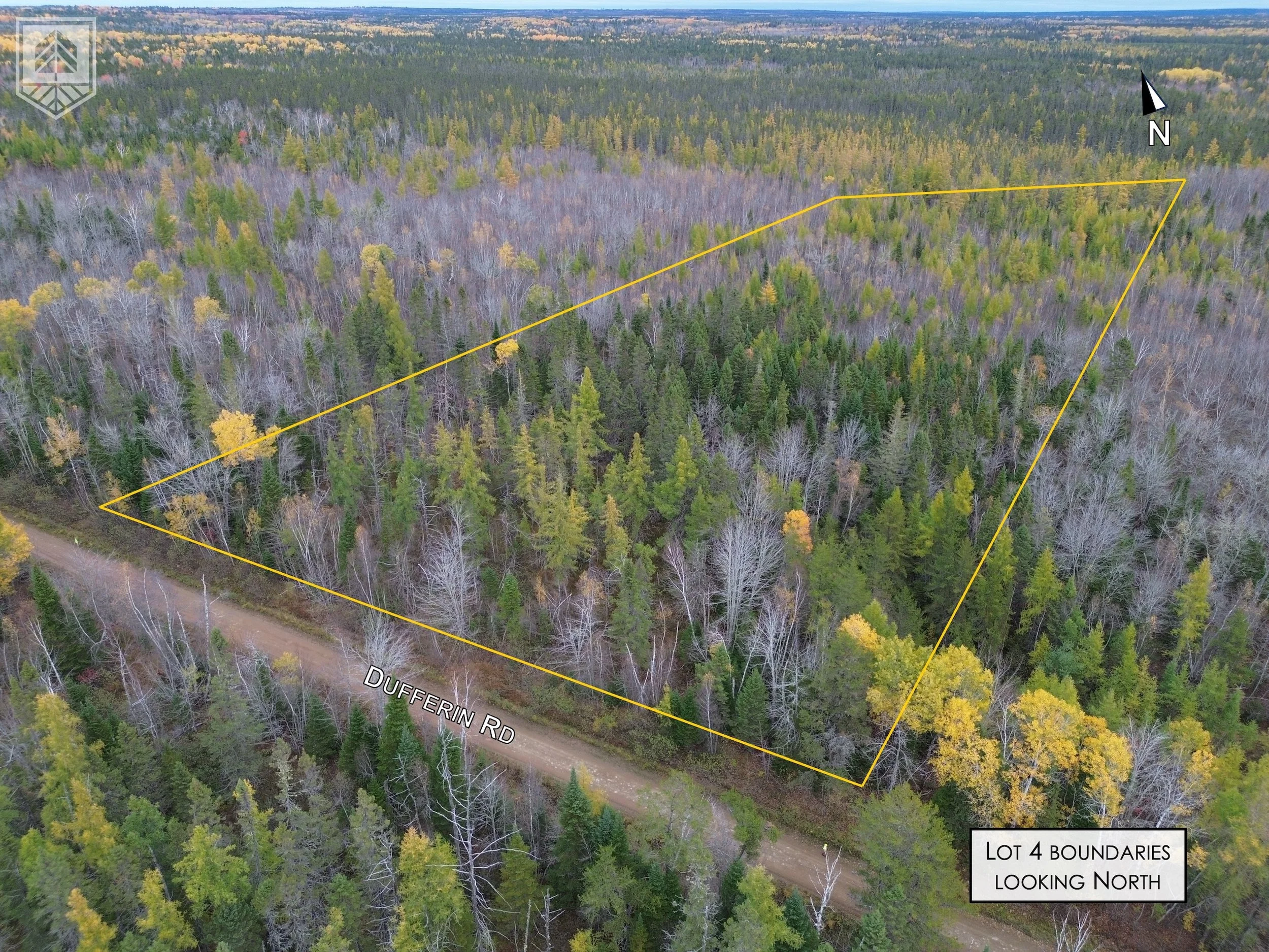 Aerial view of a forested area with tree-lined lot outlined in yellow. The lot is adjacent to Dufferin Road, which runs across the bottom of the image. The forest consists of a mix of leafless and evergreen trees, indicating a fall or early winter se