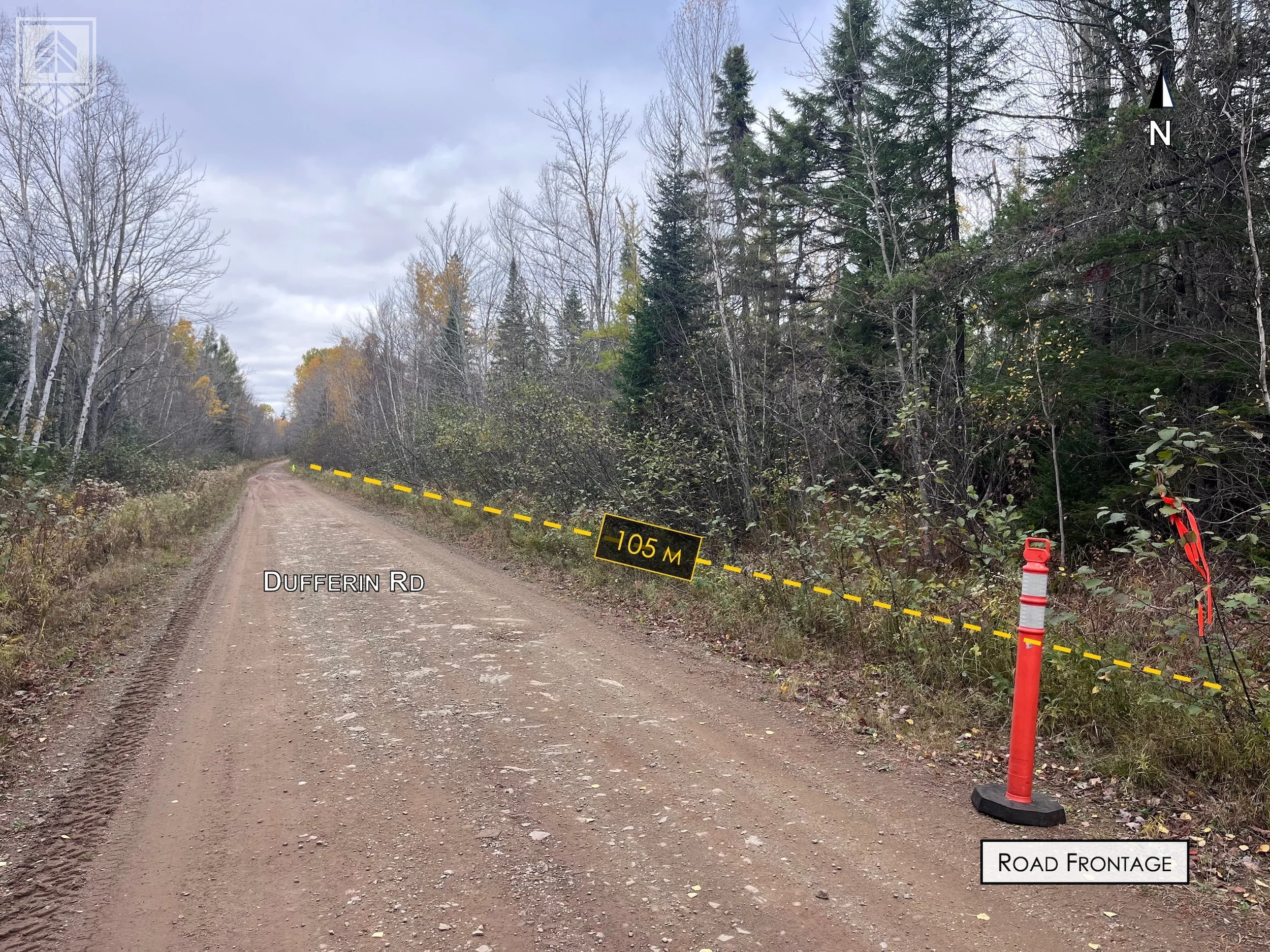 A dirt road named Dufferin Rd with a safety cone and red marker indicating a 105-meter distance to a barrier across the road, with the barrier appearing to be a tape or cord. The road is surrounded by trees, some with leaves changing color, under a c