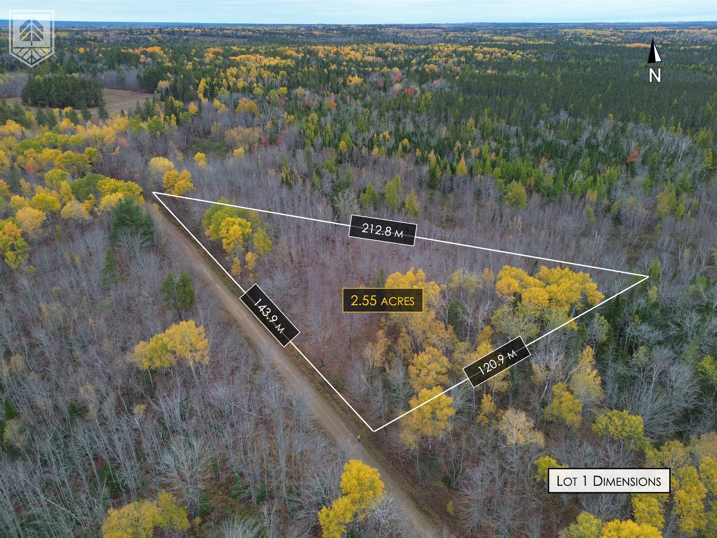 Aerial view of a wooded lot with marked dimensions of 143.9 meters, 212.8 meters, and 120.9 meters, totaling 2.55 acres, with a dirt road running along the lot's edge and surrounded by forested land with fall foliage.