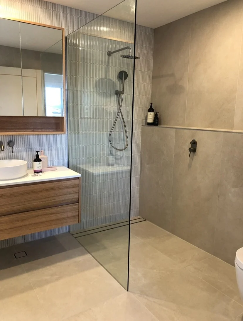 Glass walk-in shower with large wall tiles and floating vanity