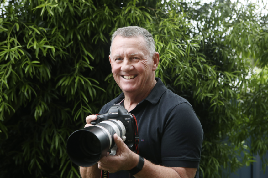 Portrait of Australian wildlife photographer John Wiseman holding his camera